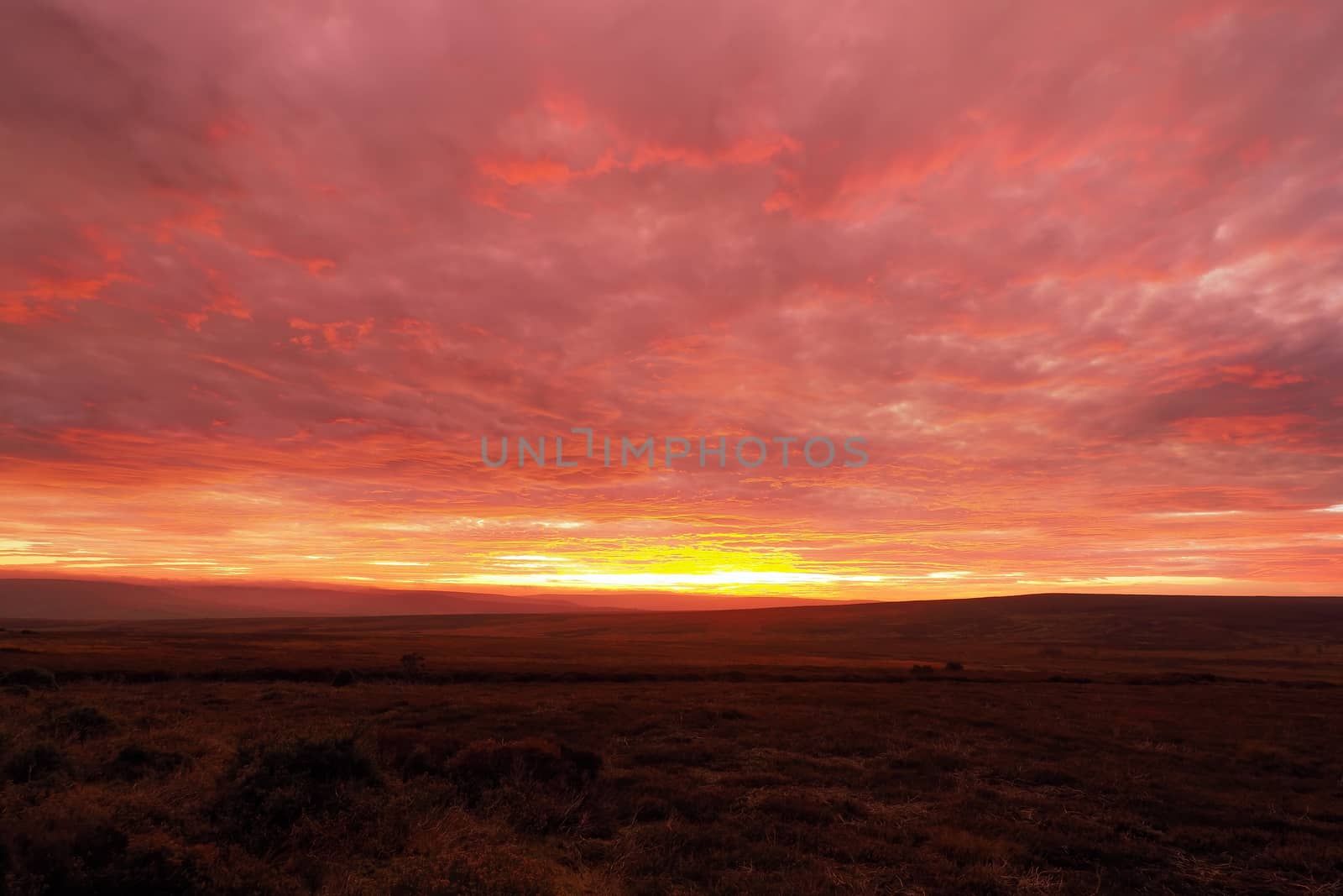 Magnificent sunset lighting up the clouds yellow, orange and red over Danby Moor, North York Moors National Park, UK