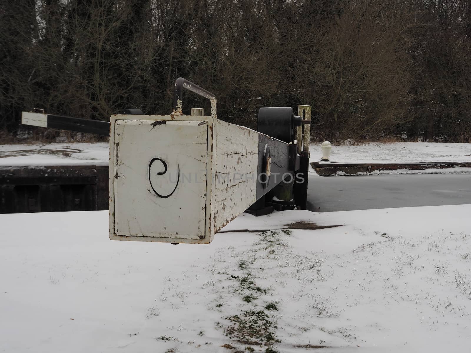 Lock gate in winter with snow on the ground and ice on the water, Padworth Lock, Kennet and Avon Canal, Berkshire, UK