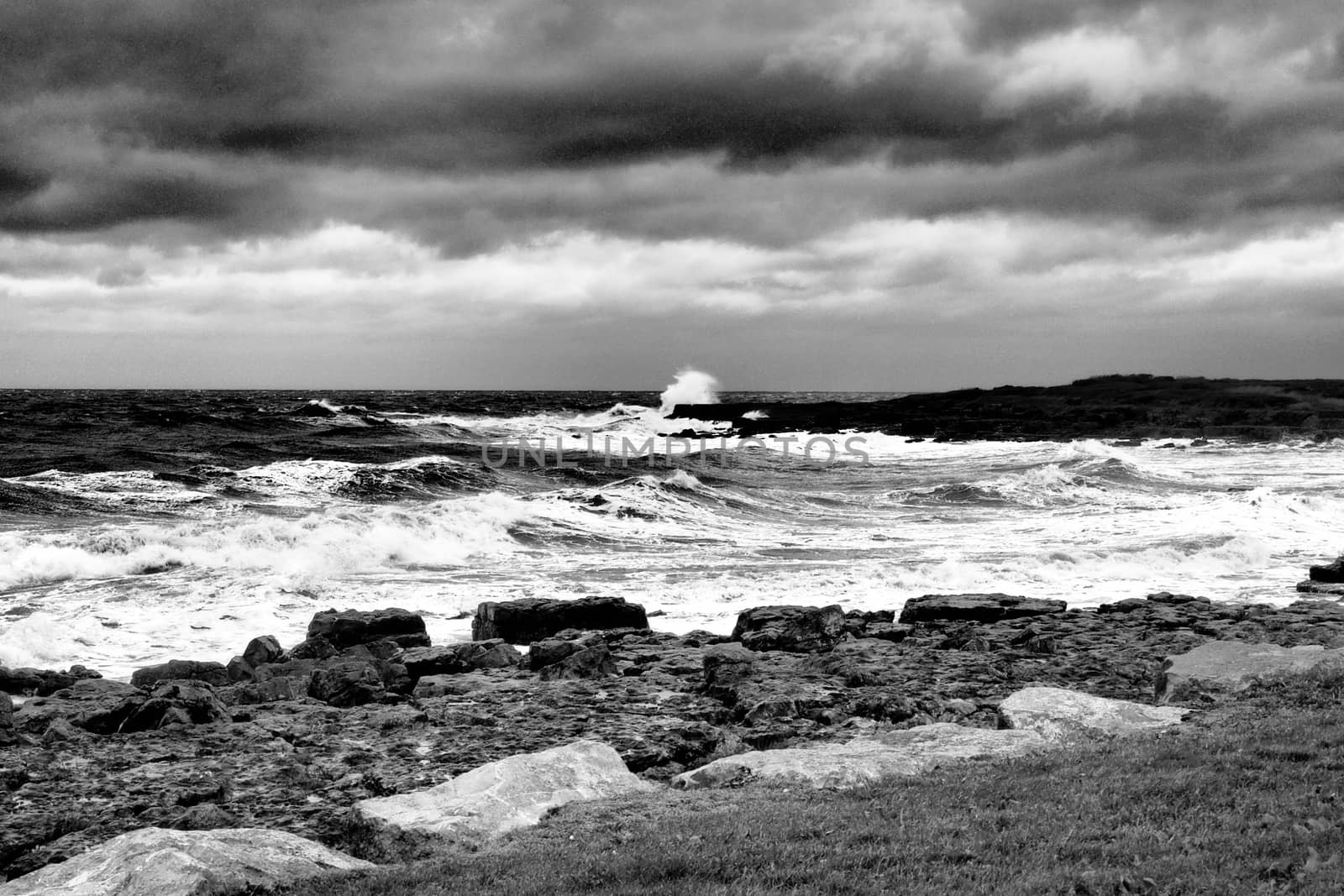 Porthcawl on a dramatic stormy day with waves crashing onto rocks, shot in monochrome, South Wales