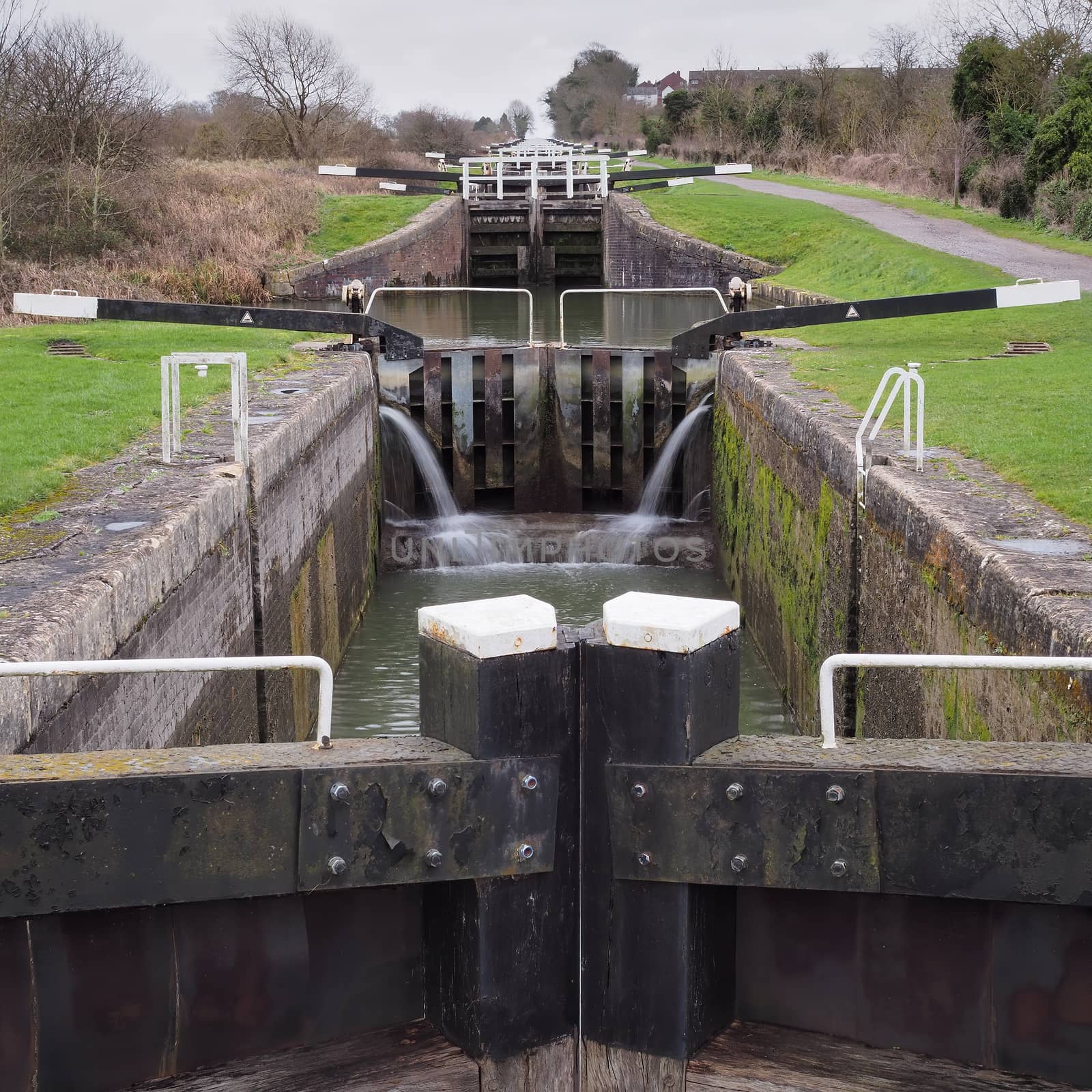 View up the flight of Caen Hill locks from the bottom lock gate on the Kennet and Avon canal, Devizes, Wiltshire, UK