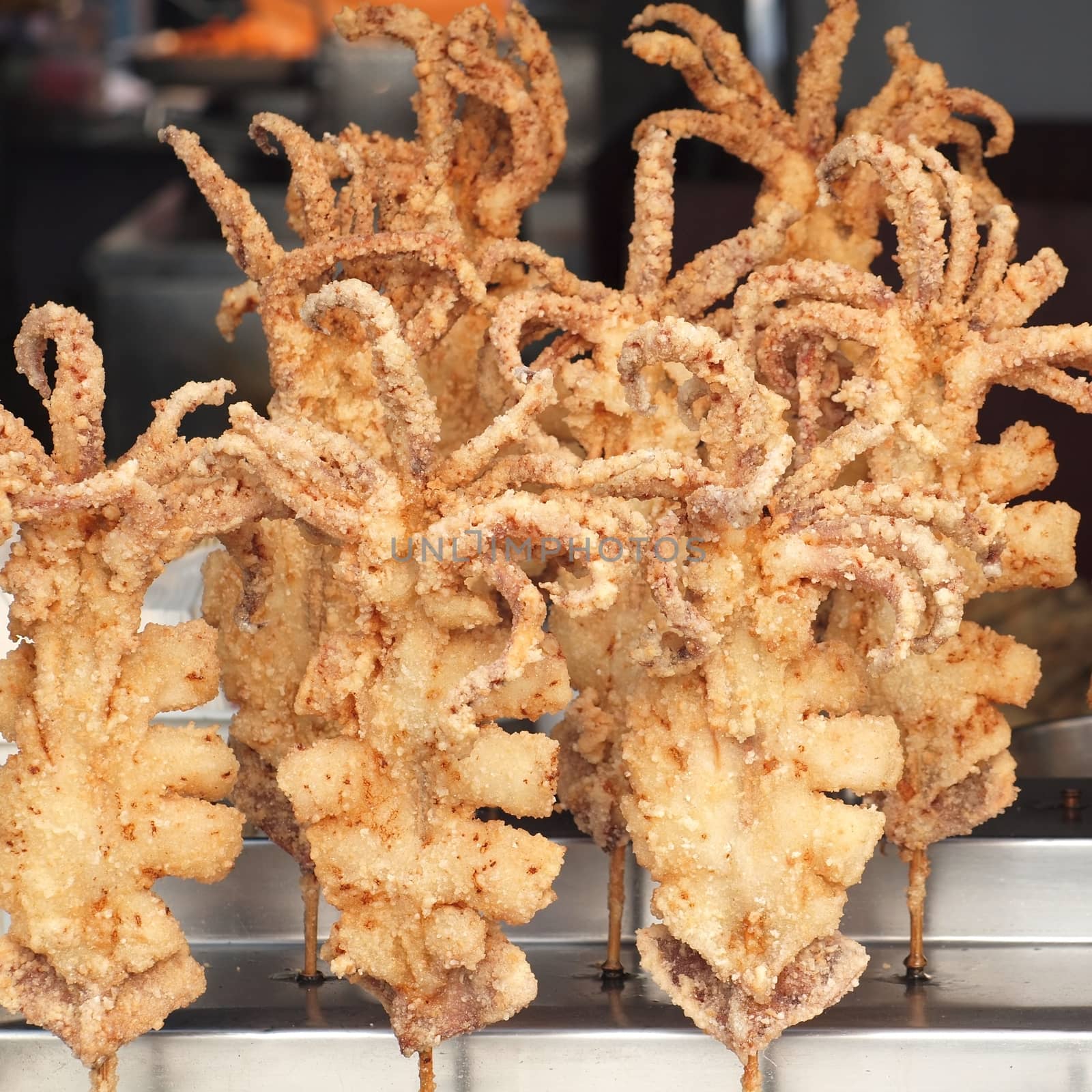 Deep fried octopus on skewers for sale at an outdoor stall

