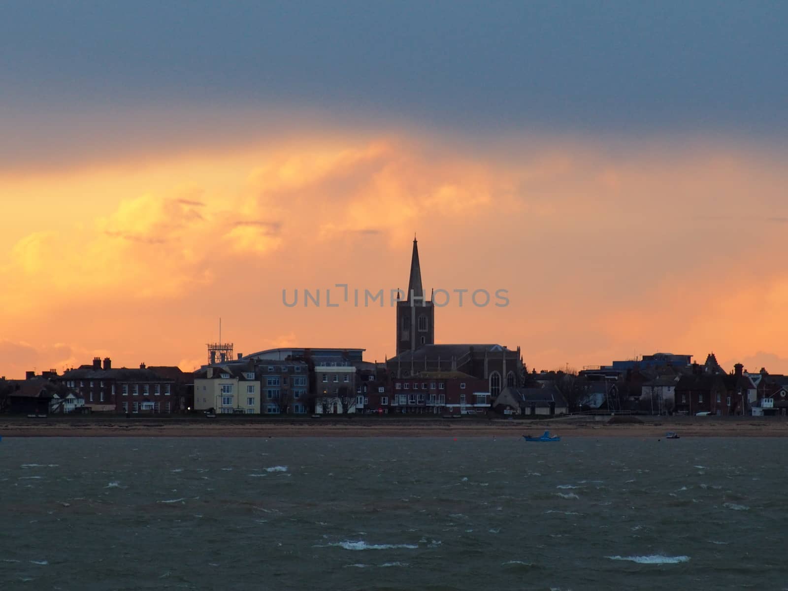 Sunset after a stormy day over a church on the seafront by PhilHarland