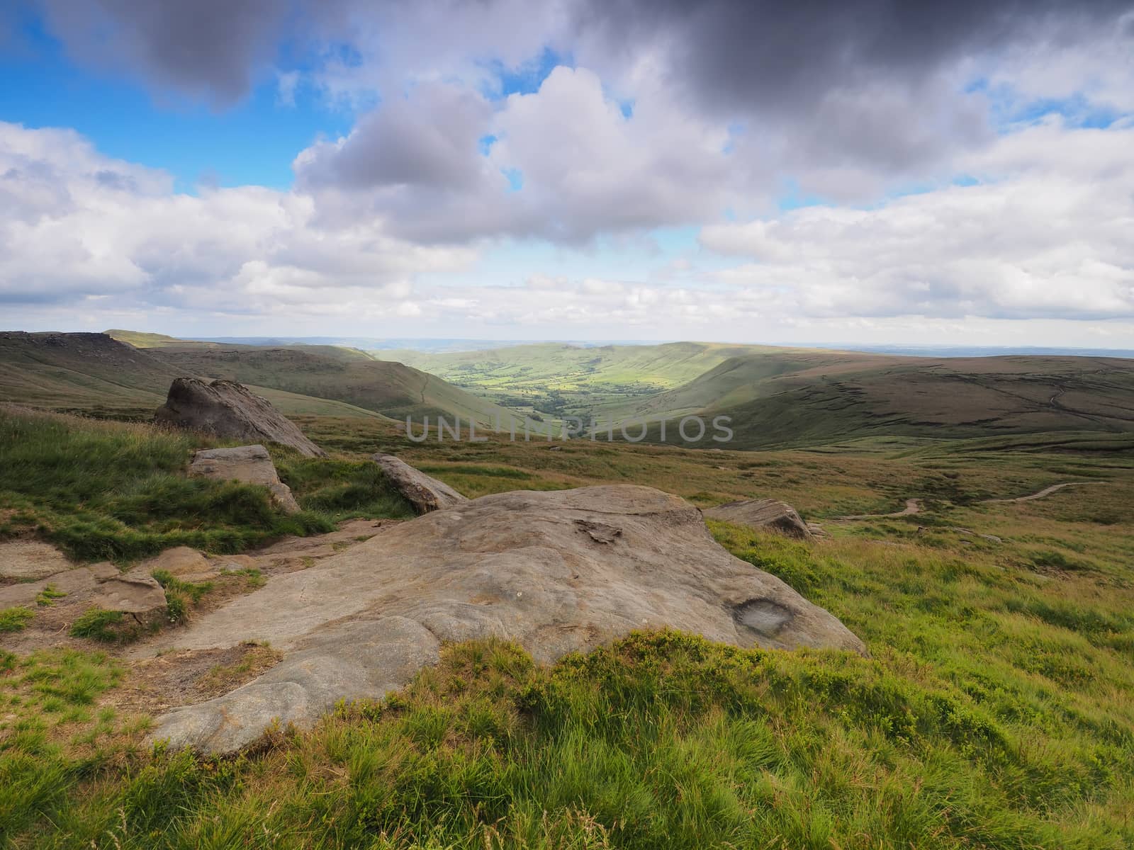 Overlooking the Edale valley from Edale Rocks on the Kinder plateau walking along the Pennine Way with dark clouds overhead, Peak District National Park, UK