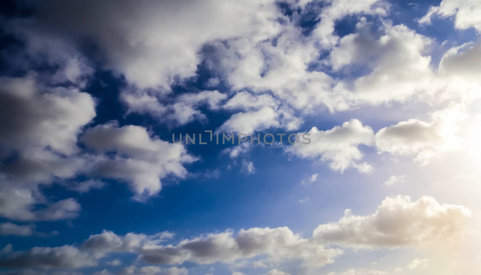 Beautiful fluffy white beautiful cloud formations in a deep blue summer sky