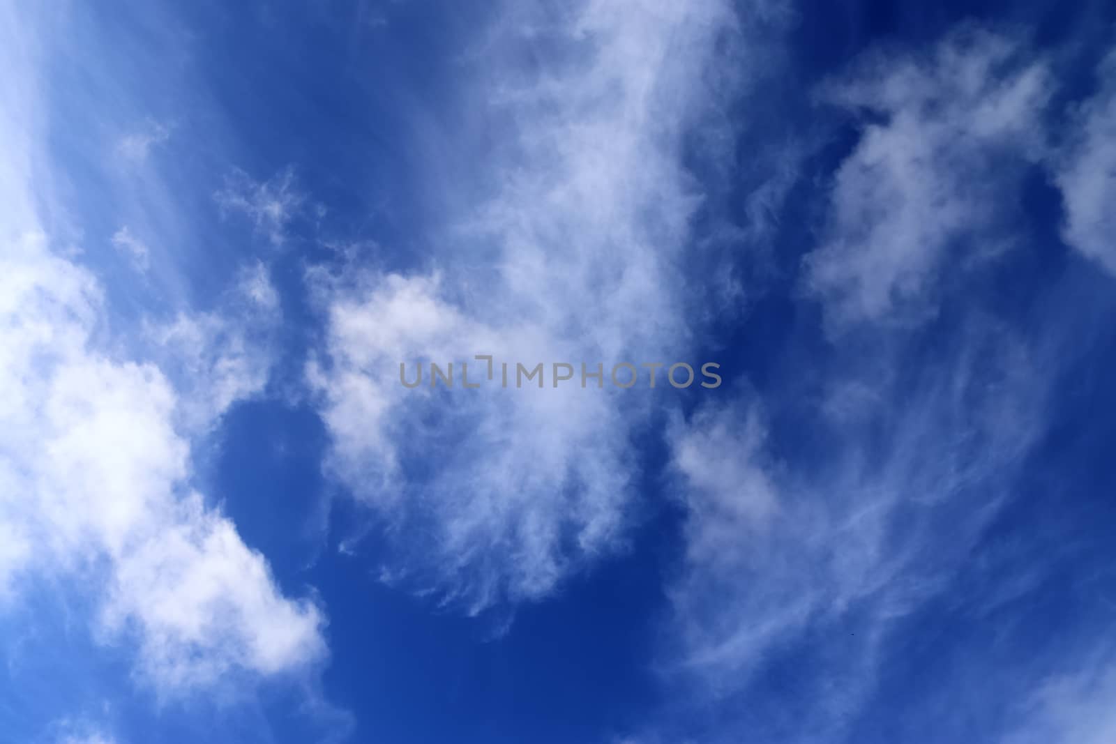 Beautiful fluffy white beautiful cloud formations in a deep blue summer sky