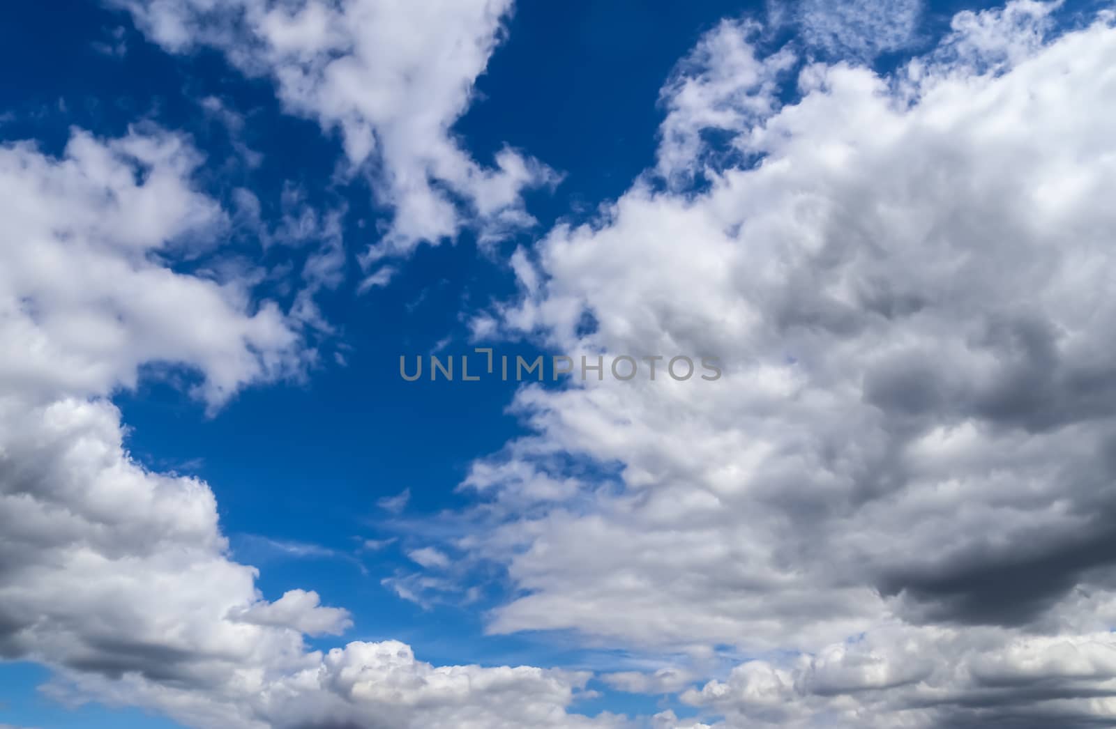 Beautiful fluffy white beautiful cloud formations in a deep blue summer sky