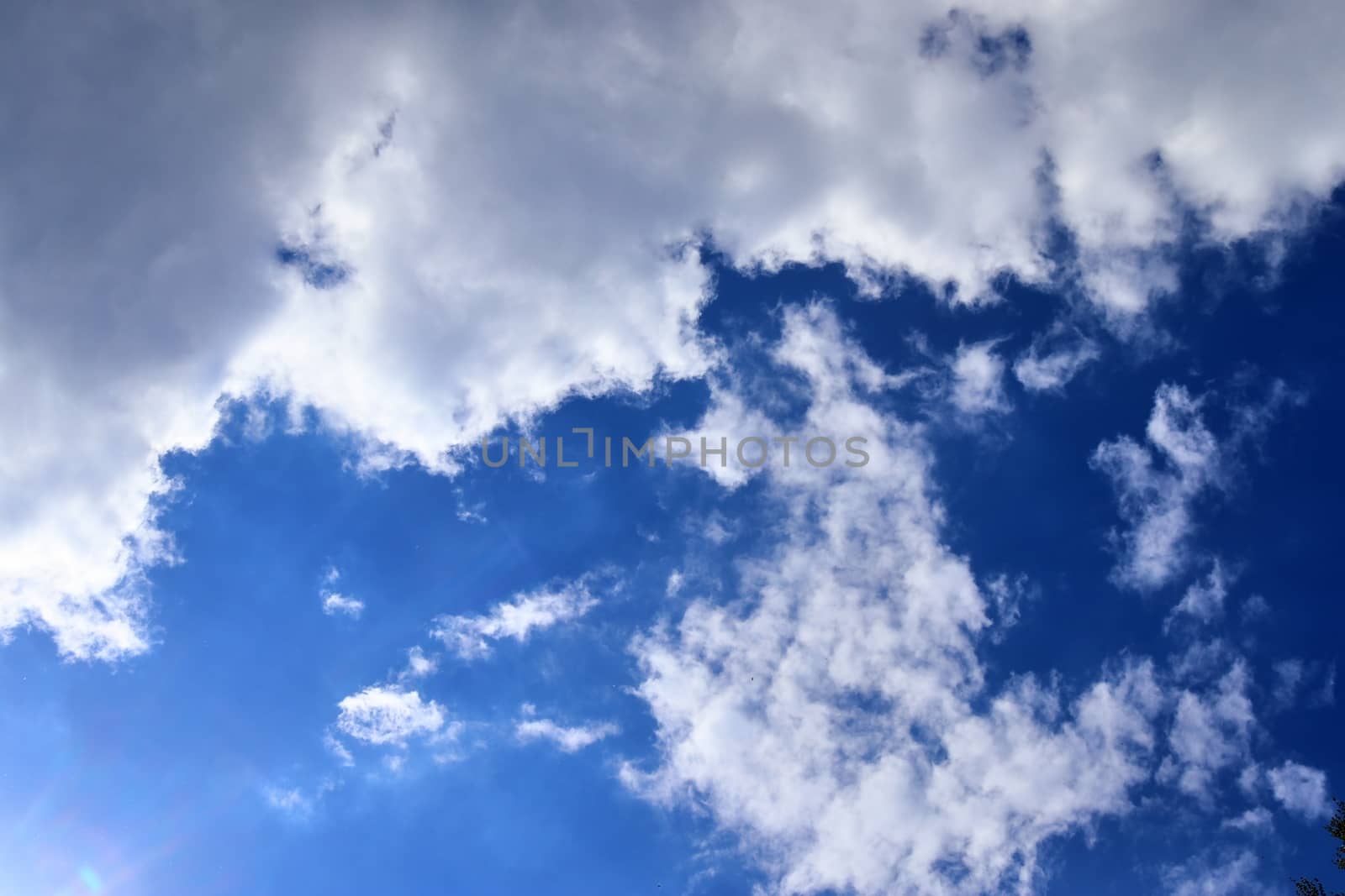 Beautiful fluffy white beautiful cloud formations in a deep blue summer sky