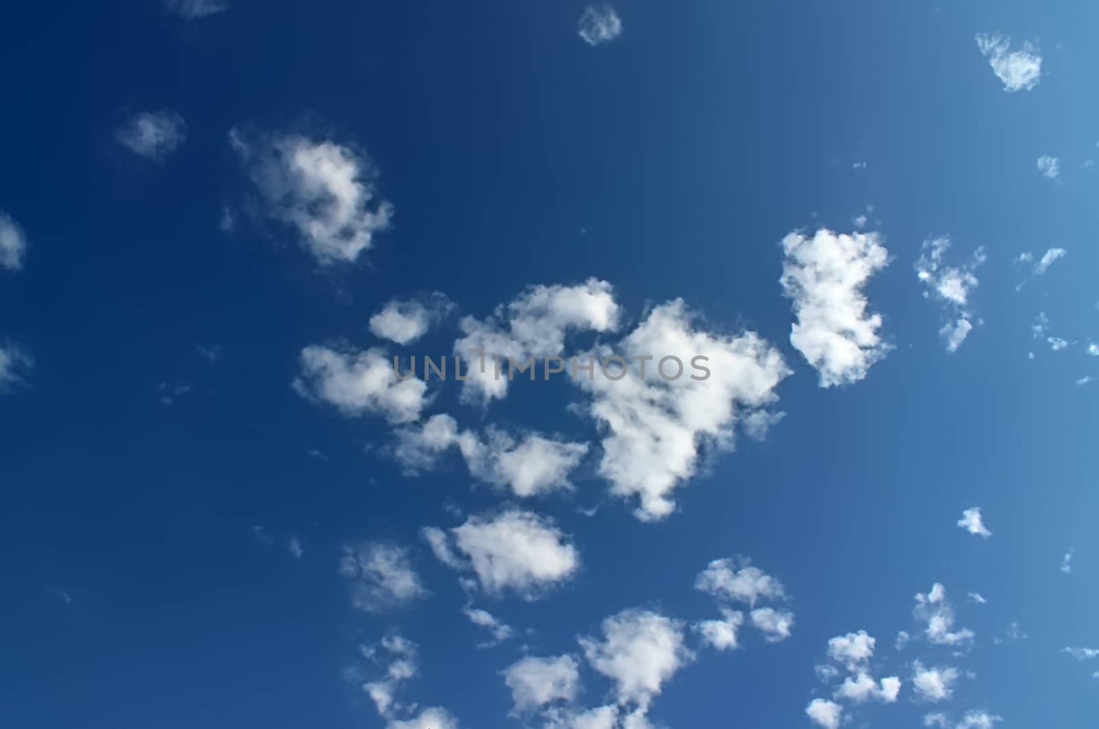 Beautiful fluffy white beautiful cloud formations in a deep blue summer sky