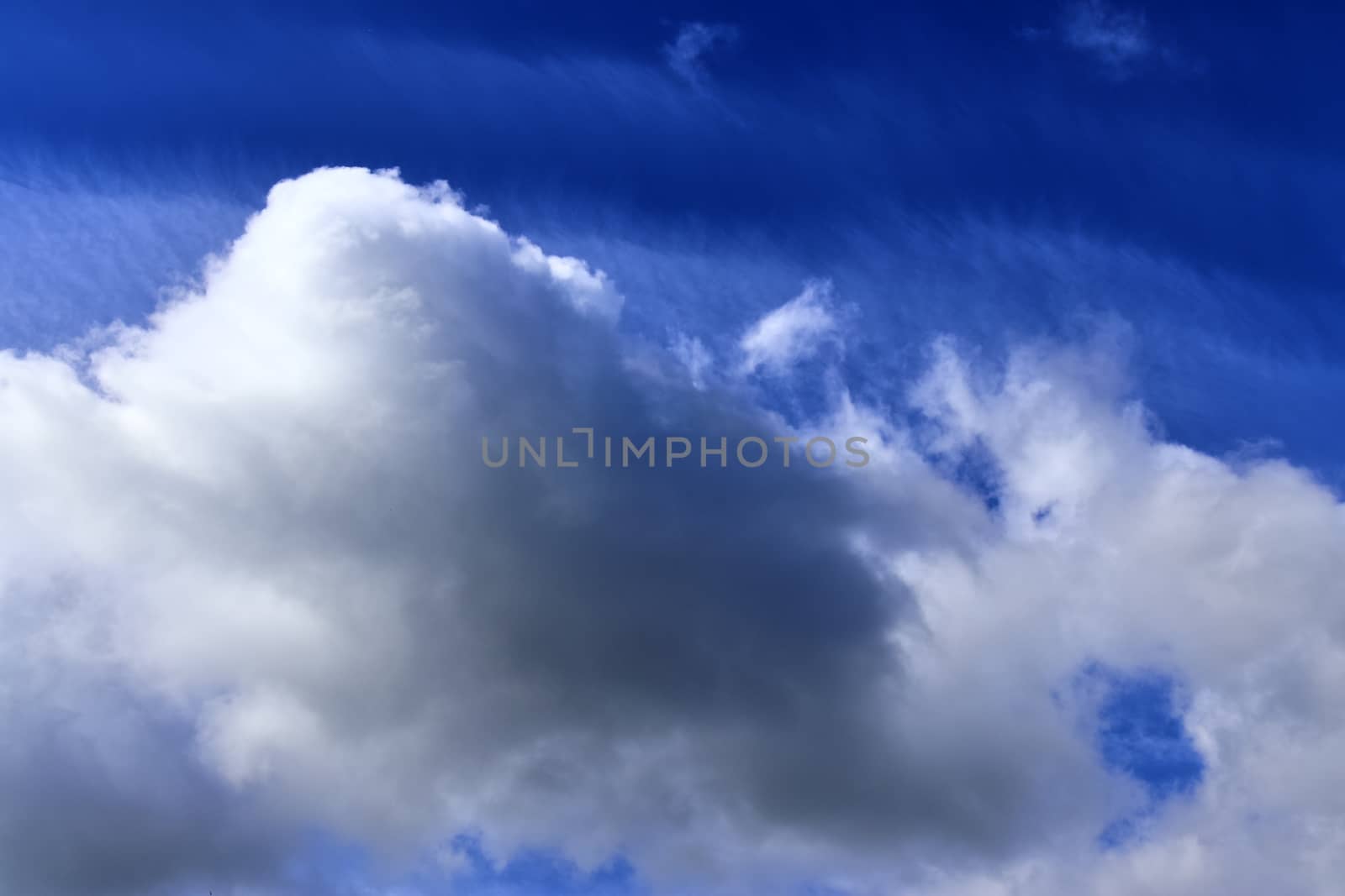 Beautiful fluffy white beautiful cloud formations in a deep blue summer sky