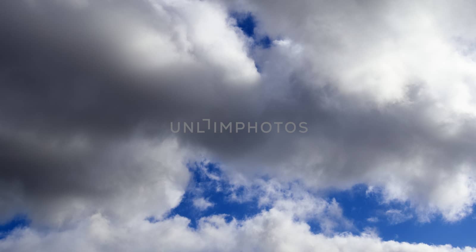 Beautiful fluffy white beautiful cloud formations in a deep blue summer sky