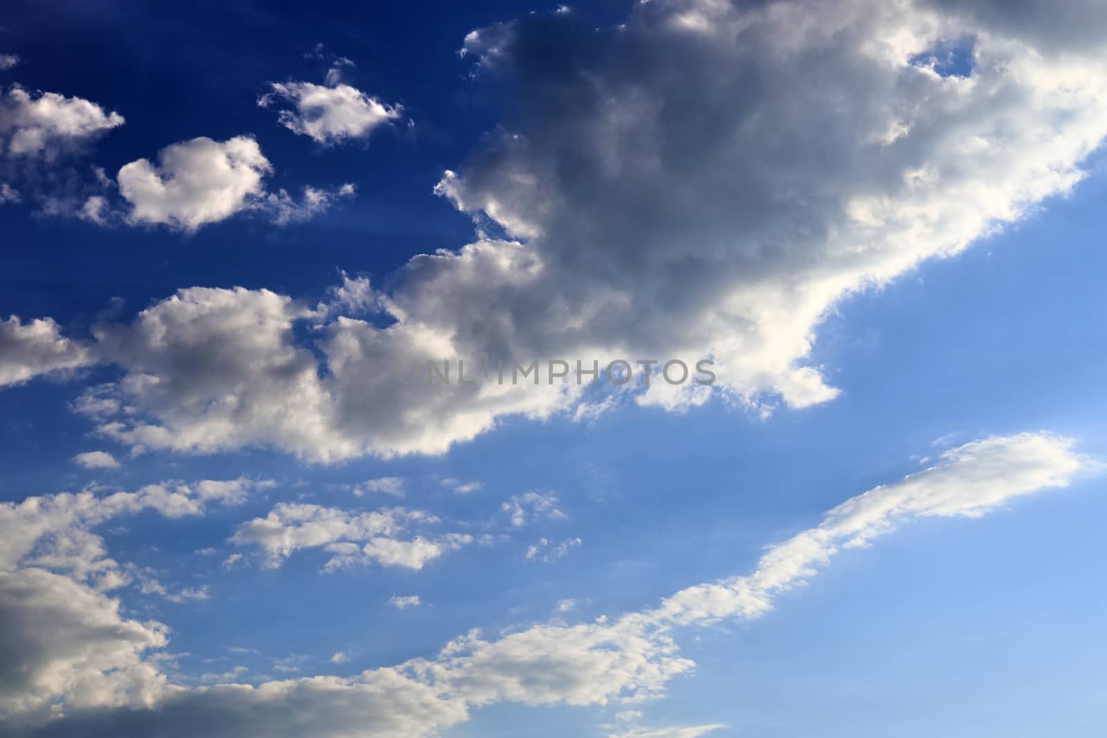 Beautiful fluffy white beautiful cloud formations in a deep blue summer sky