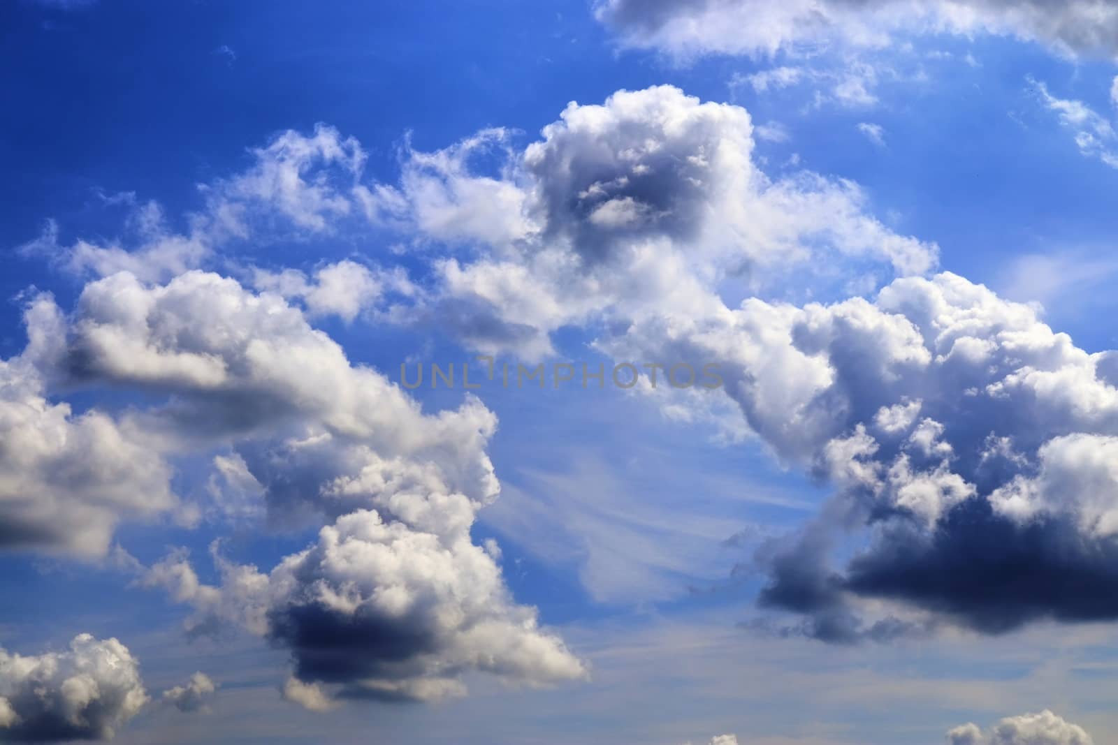 Beautiful fluffy white beautiful cloud formations in a deep blue summer sky