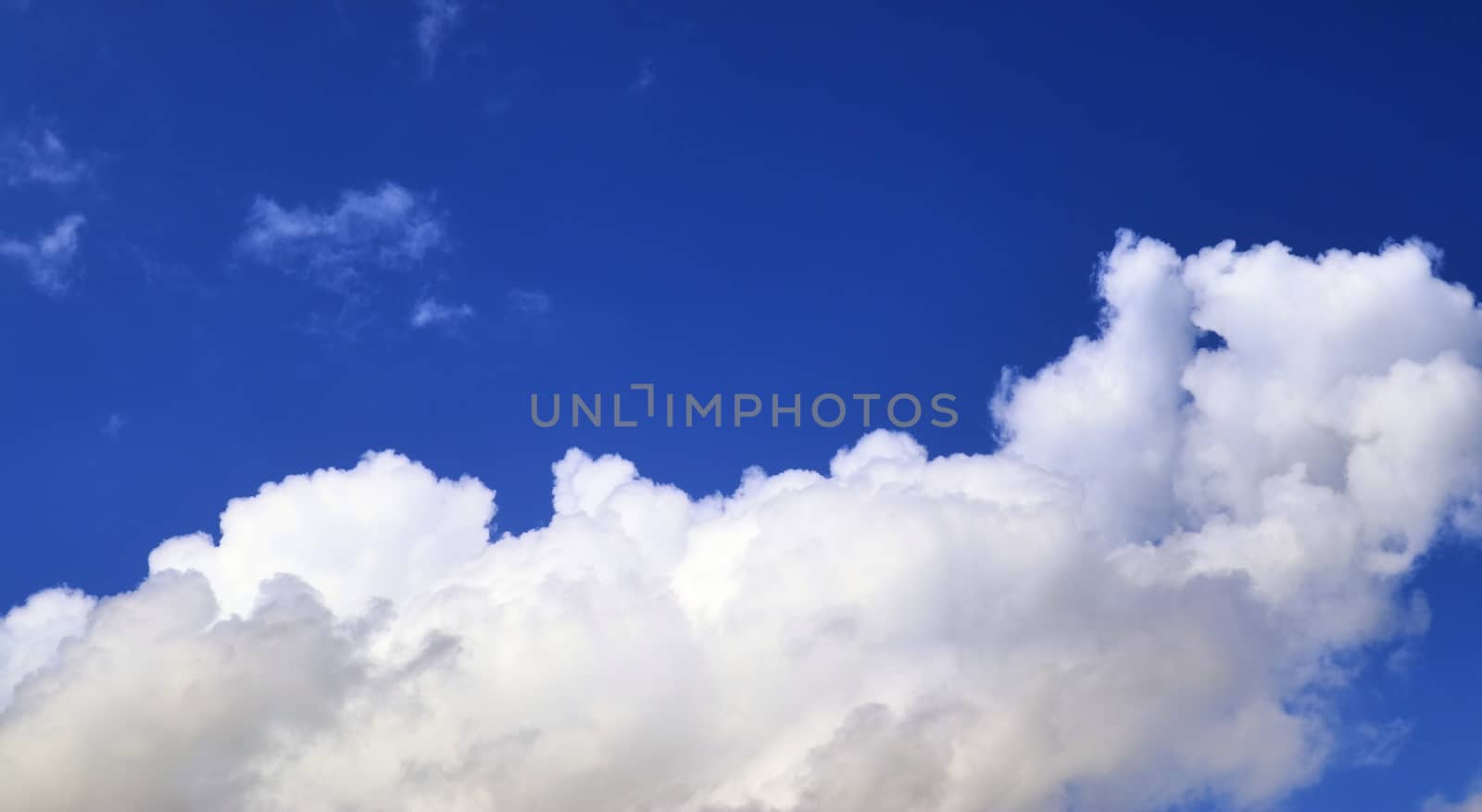 Beautiful fluffy white beautiful cloud formations in a deep blue summer sky