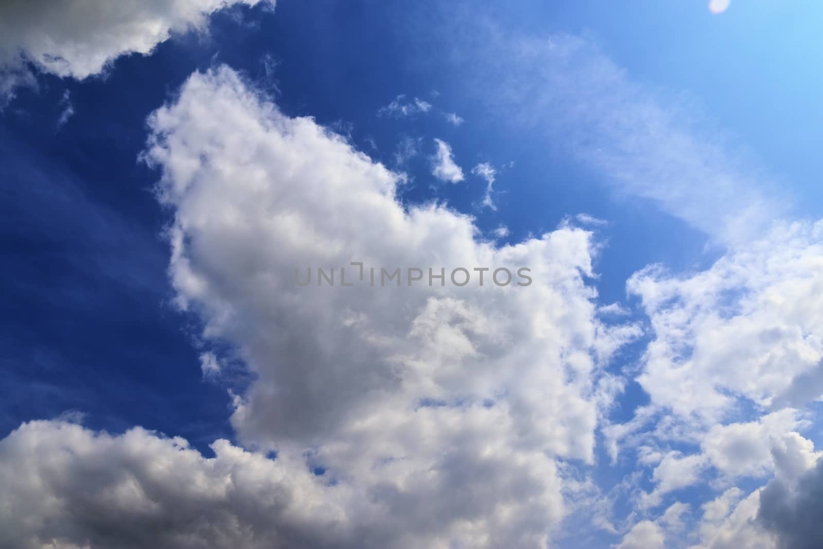 Beautiful fluffy white beautiful cloud formations in a deep blue summer sky