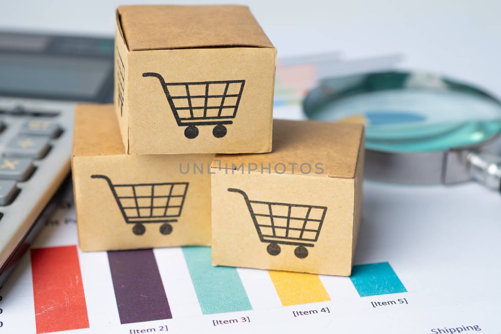 Shopping cart logo on box with calculator on graph background. Banking Account, Investment Analytic research data economy, trading, Business import export transportation online company concept. by pamai