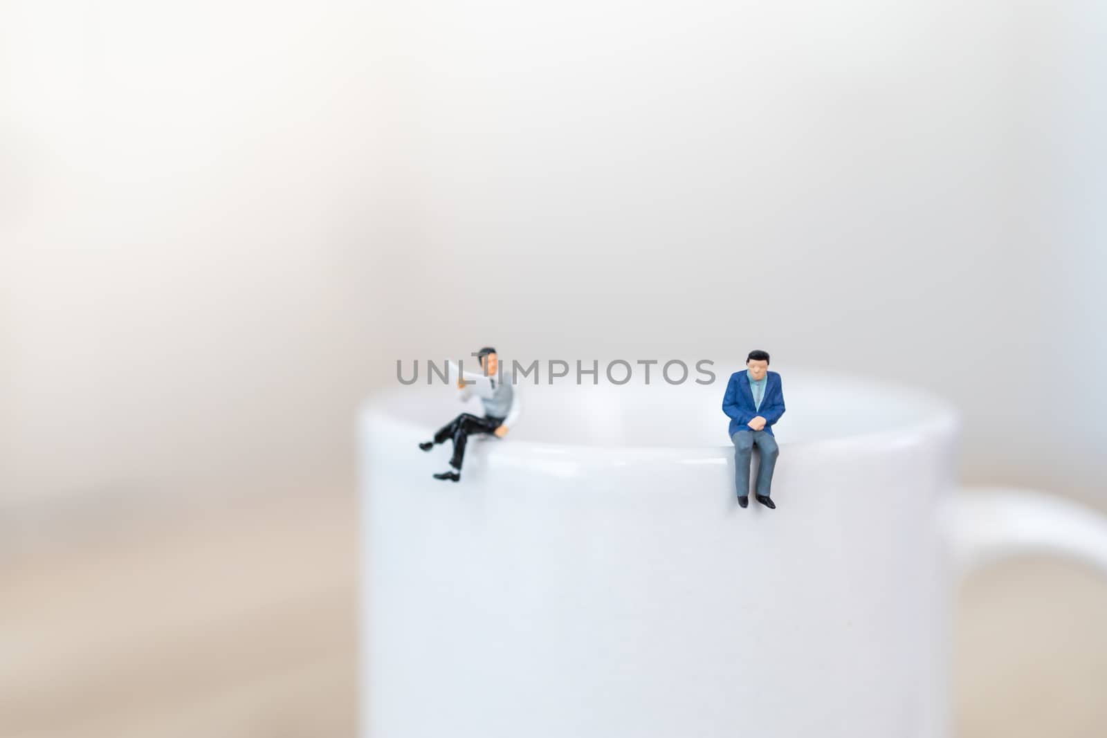 Two businessman miniature figure people standing on top of white by mthipsorn