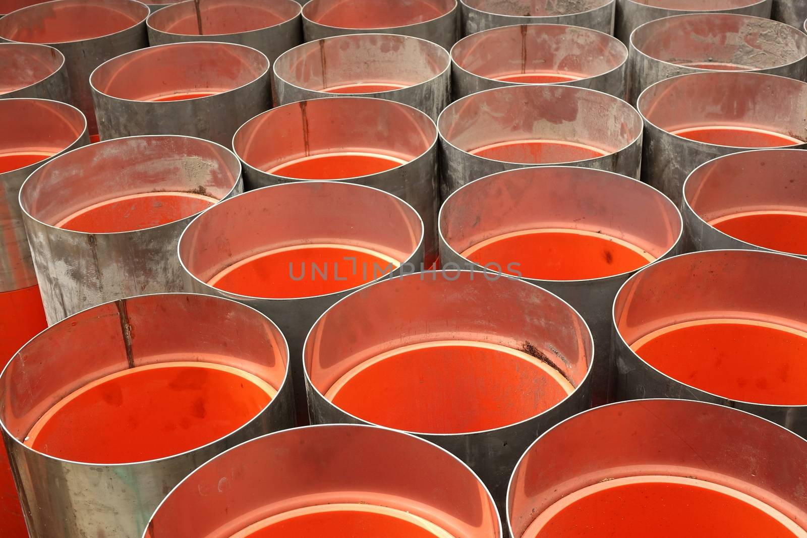 Large orange PVC pipes with stainless steel metal caps
