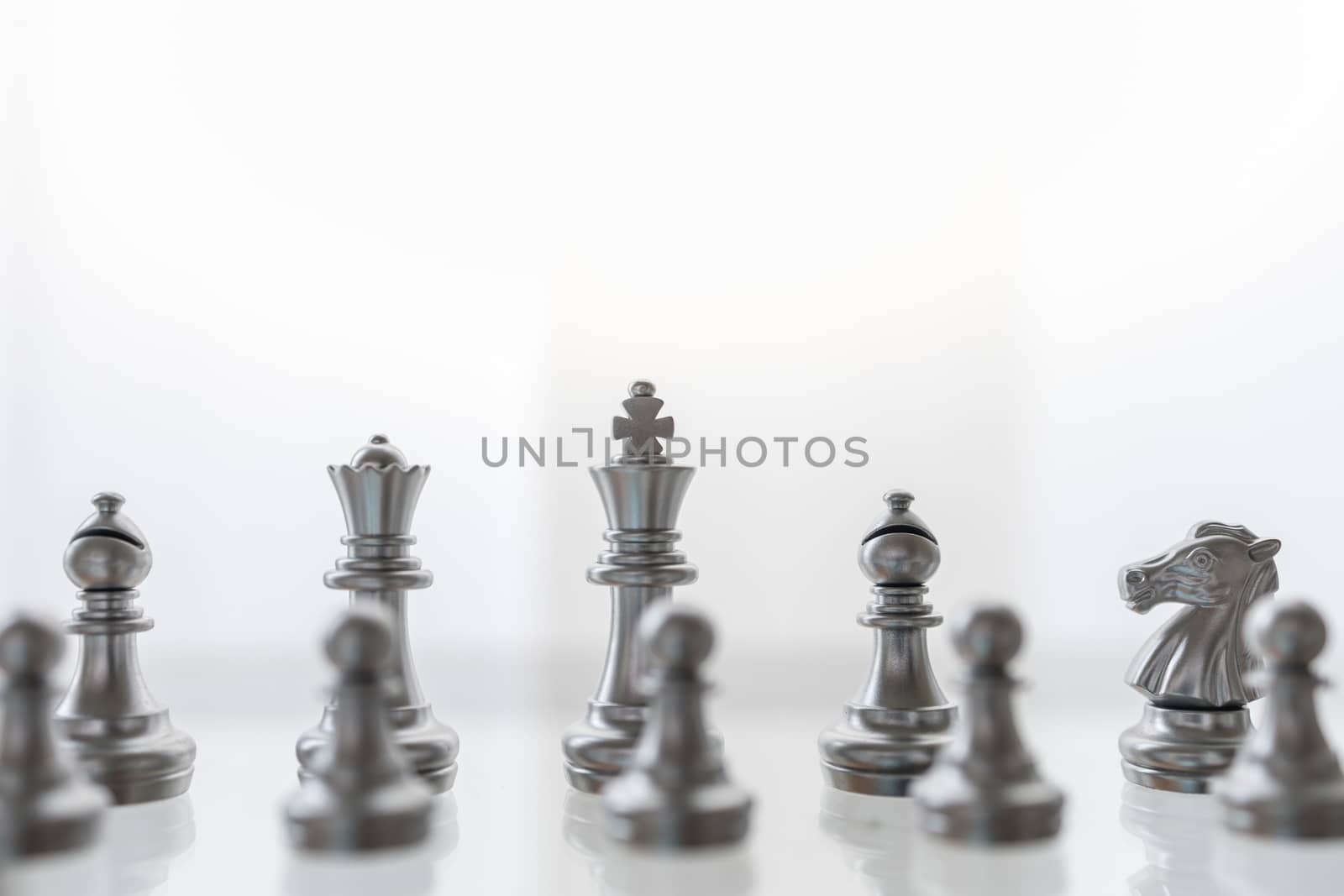 Sport board game, Business and planning concept. Closeup of King, Queen, Bishop, knight and pawn silver chess pieces on glass table.