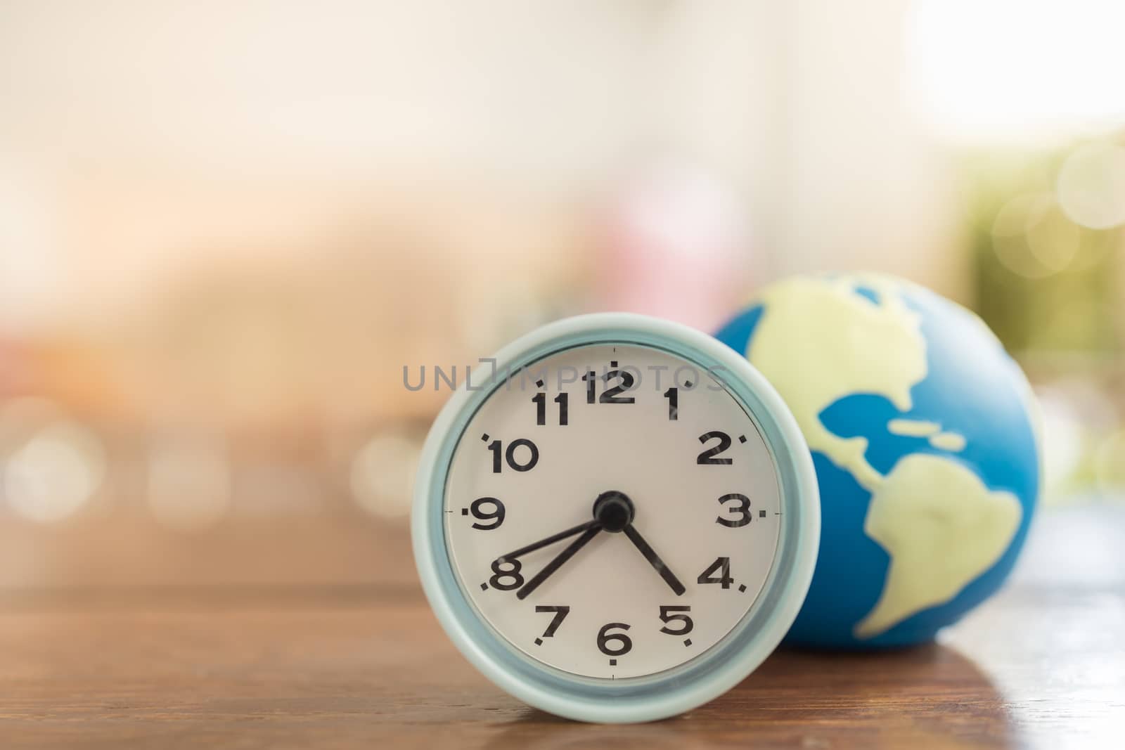 Global Time, Planning and Management Concept. Close up of vintage round clock with mini world ball on wooden table. and copy space.