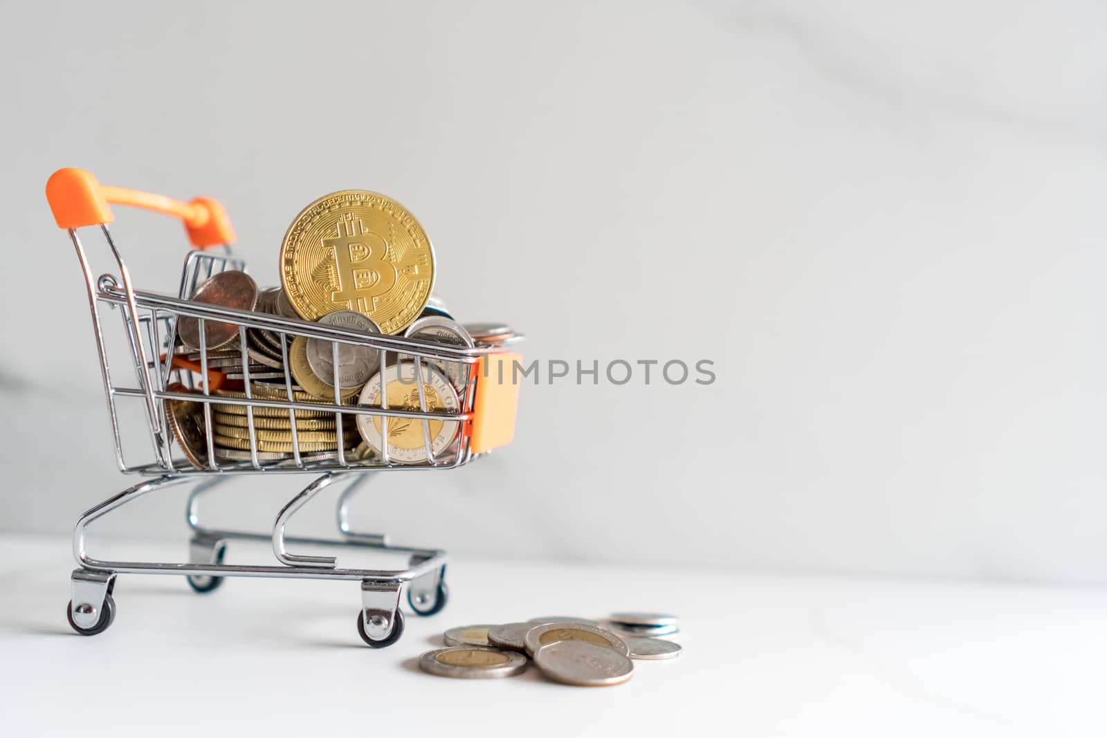 Bitcoin or cryptocurrency symbol in mini cart model full of coins money with copyspace white background.