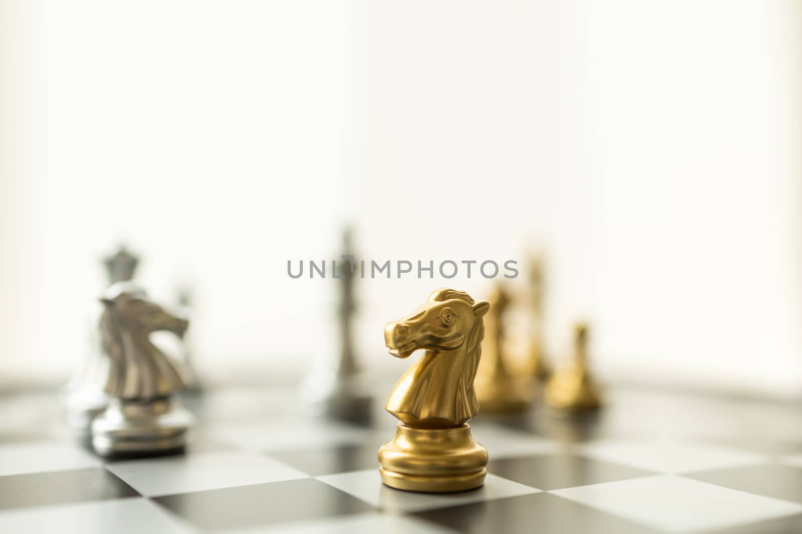 Sport board game, Business and planning concept. Closeup of knight chess piece on chessboard with other pieces.