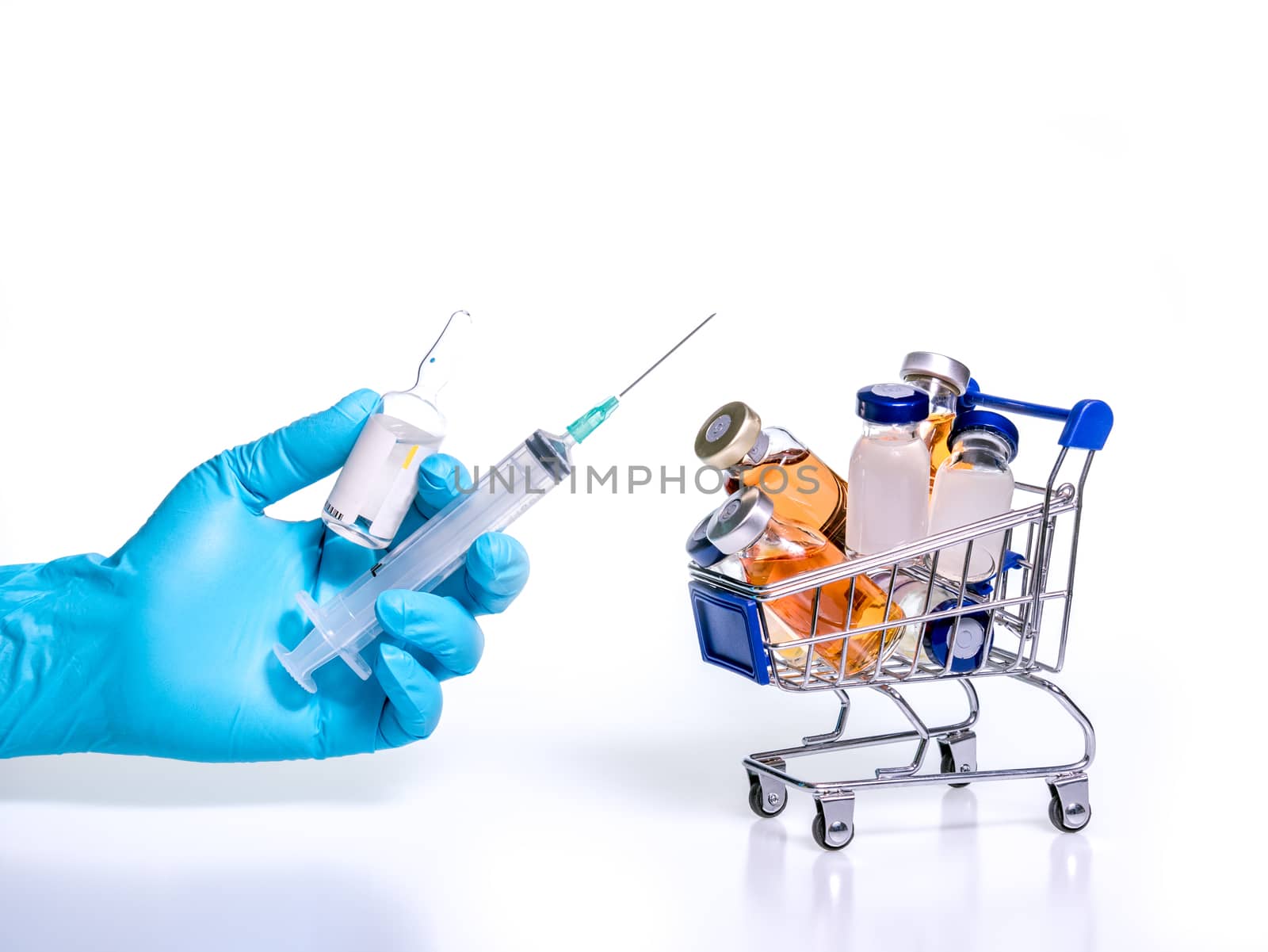 hand with blue latex glove holding medical vial with solution for injection and syringe ,and many medical vials in shopping cart, on white background.Vaccine trails for covid-19, can be affordable and accessible.
