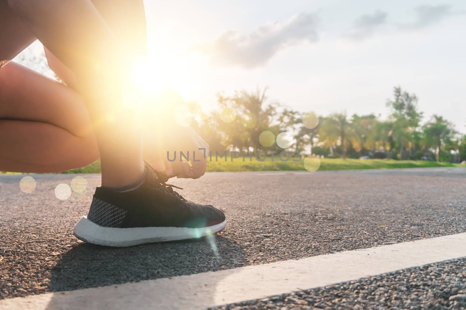 Woman wear running shoe on to walking and running on nature green background.Health exercise. by Suwant