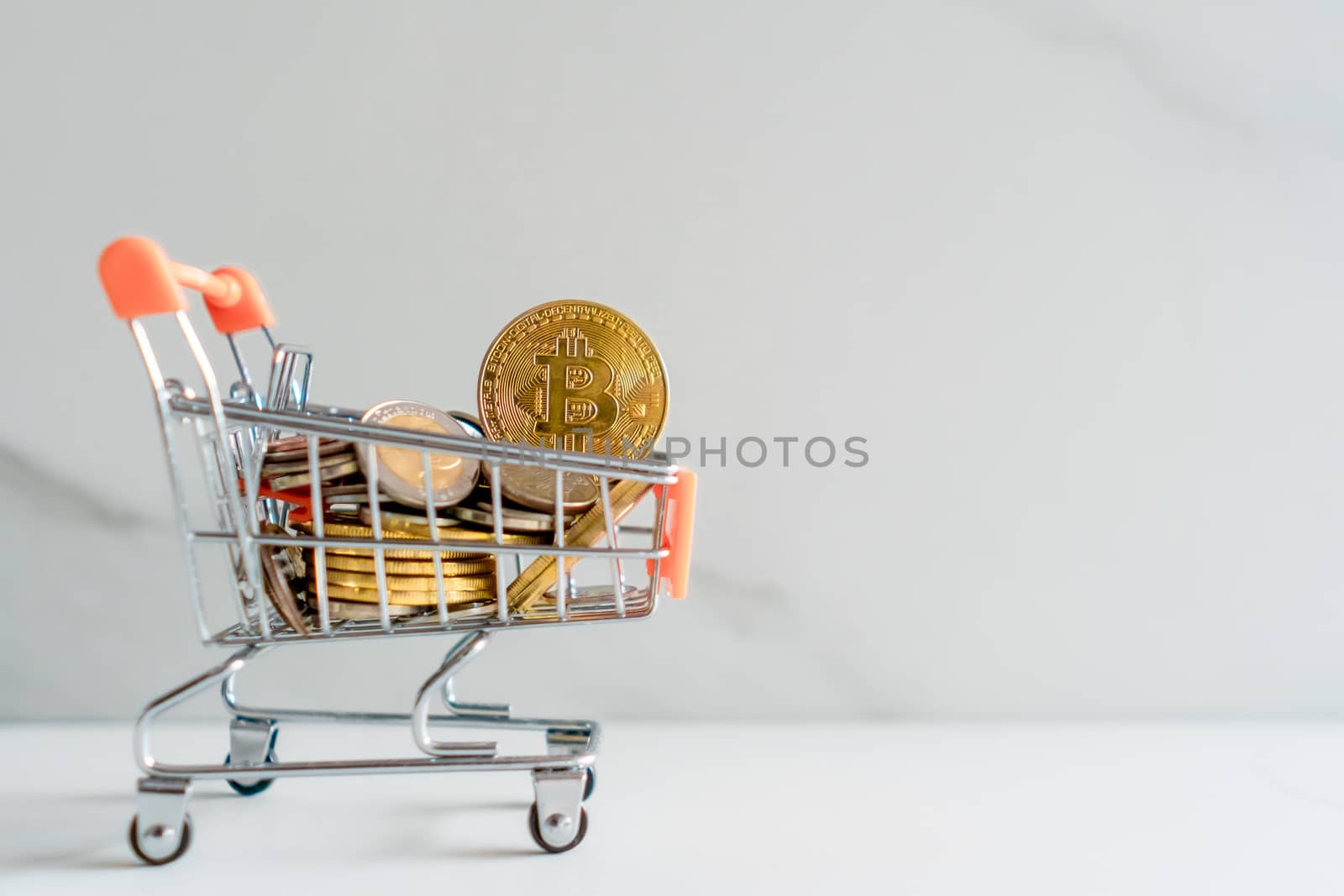 Bitcoin or cryptocurrency symbol in mini cart model full of coins money with copyspace white background.