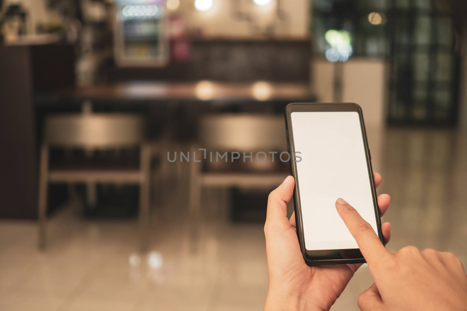 Woman hand use smartphone to do work business, social network, communication in public cafe work space area.