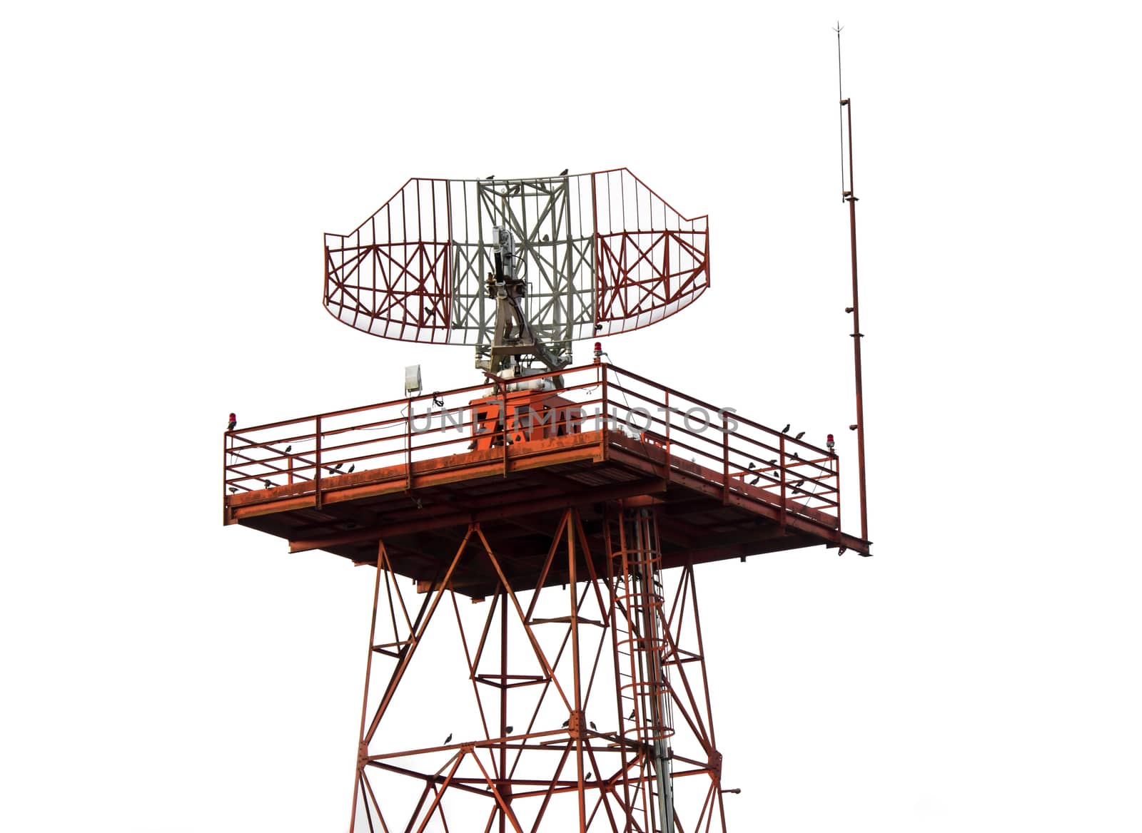 Red and white metal radar tower in airport area with plane landing