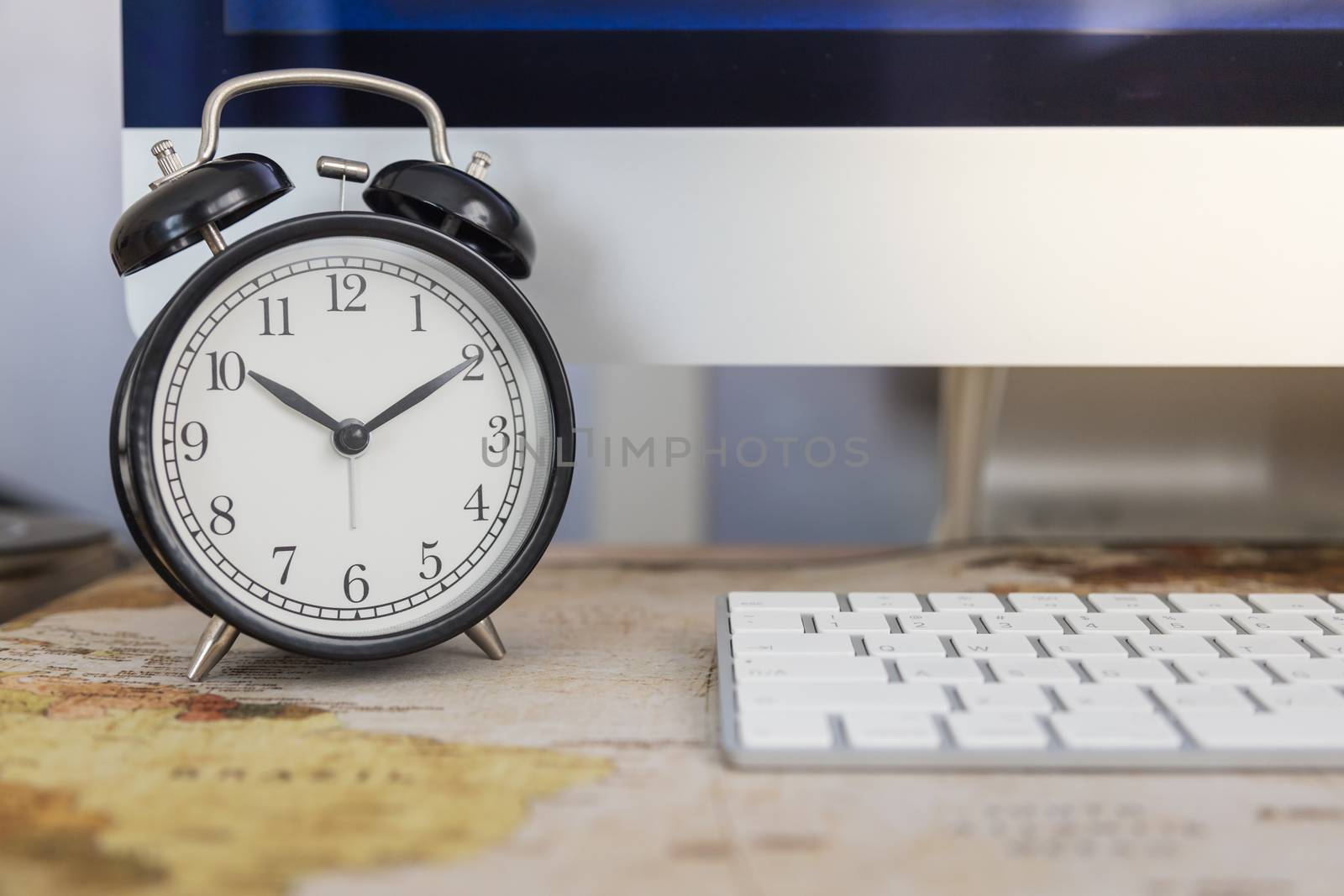 Business, Time, Technology Concept. Close up of vintage alarm clock with desktop computer and keyboard on working desk.