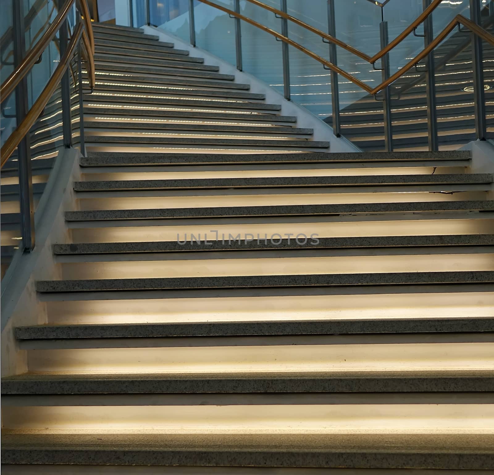 A curved staircase leading upwards with indirect lighting
