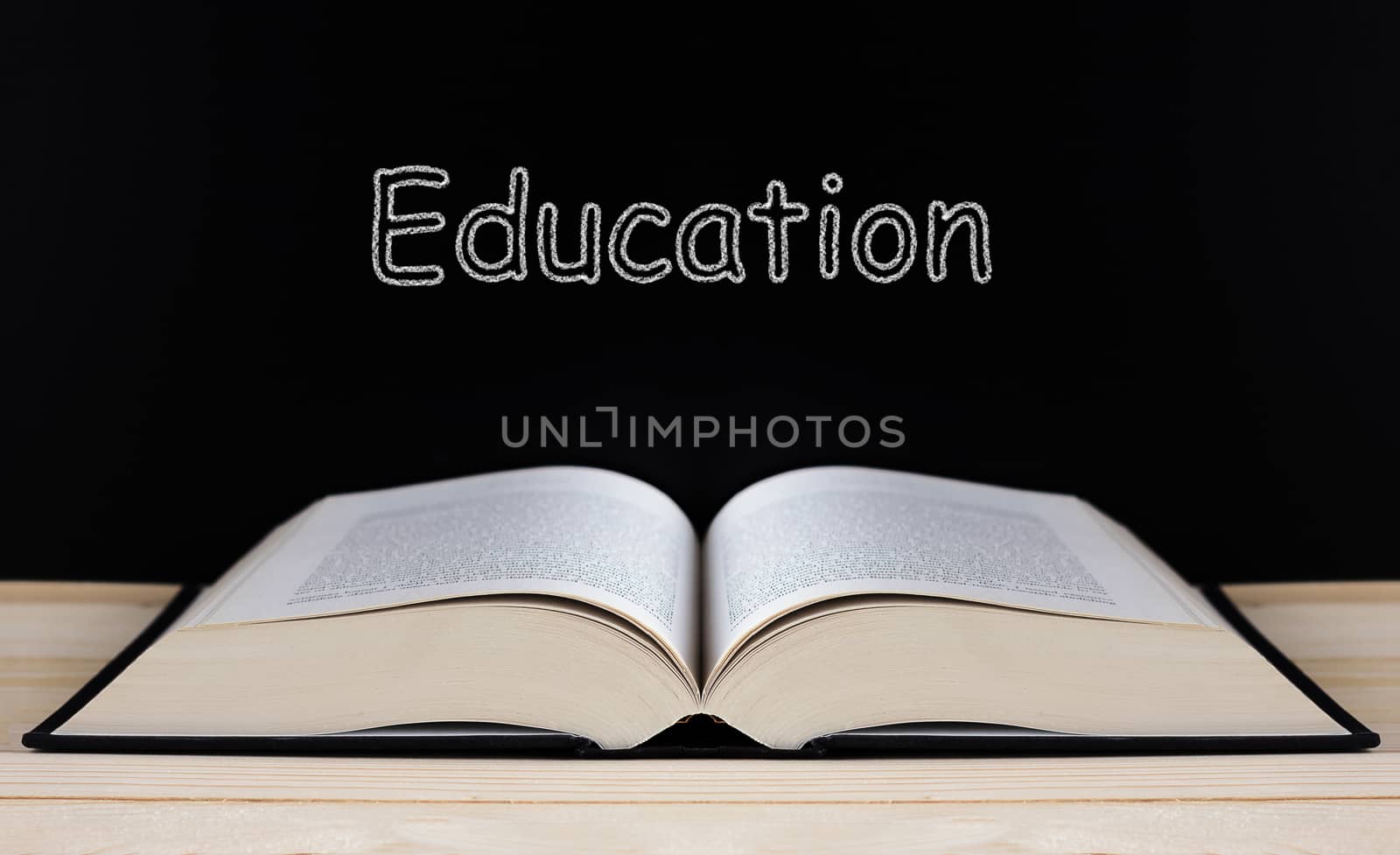 Book on blackboard background, education concept