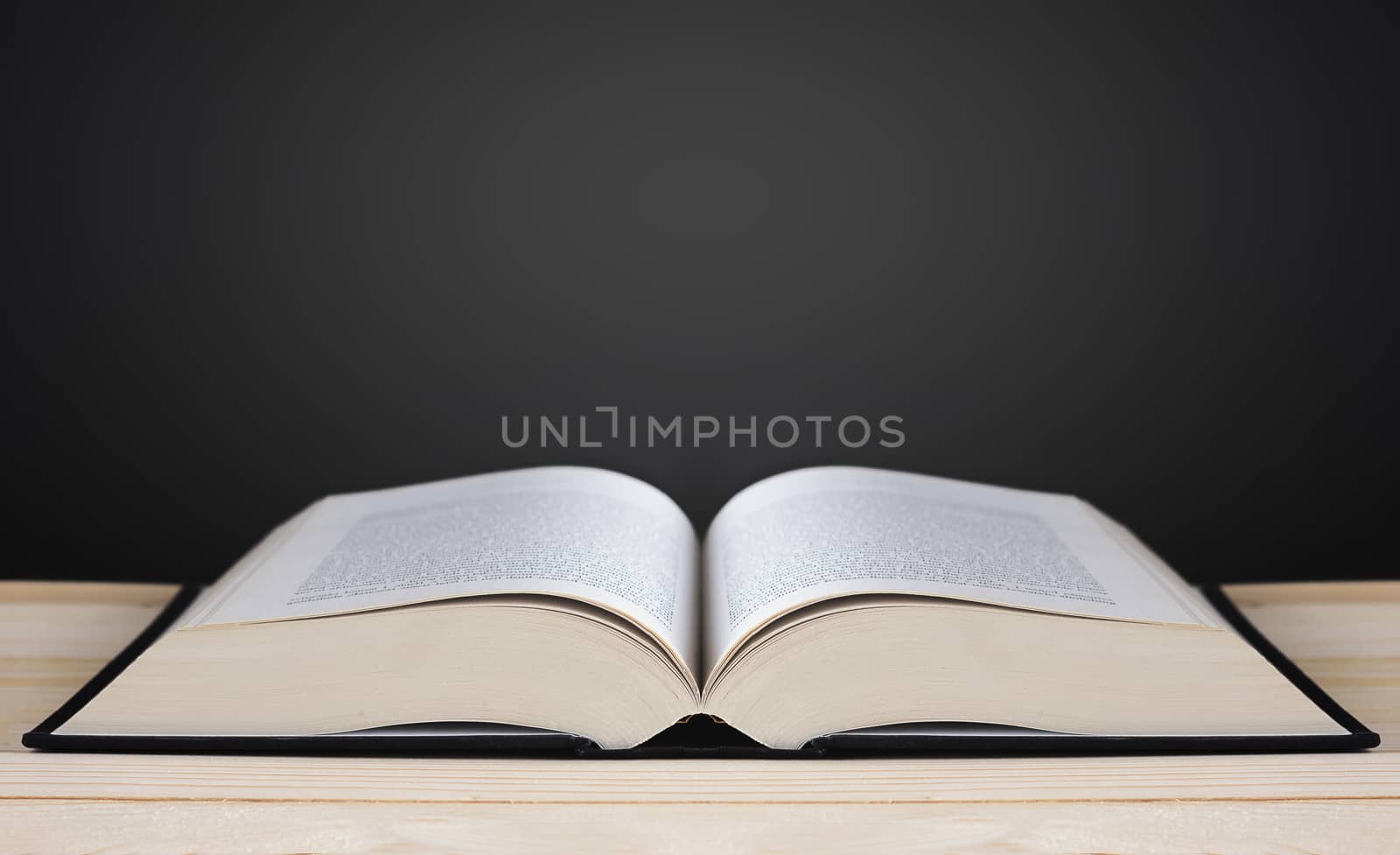 Book on blackboard background, copy space and light, education concept