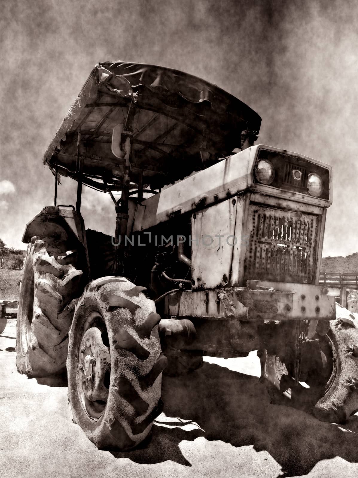 A rusting and corroded old tractor seen against a grungy background