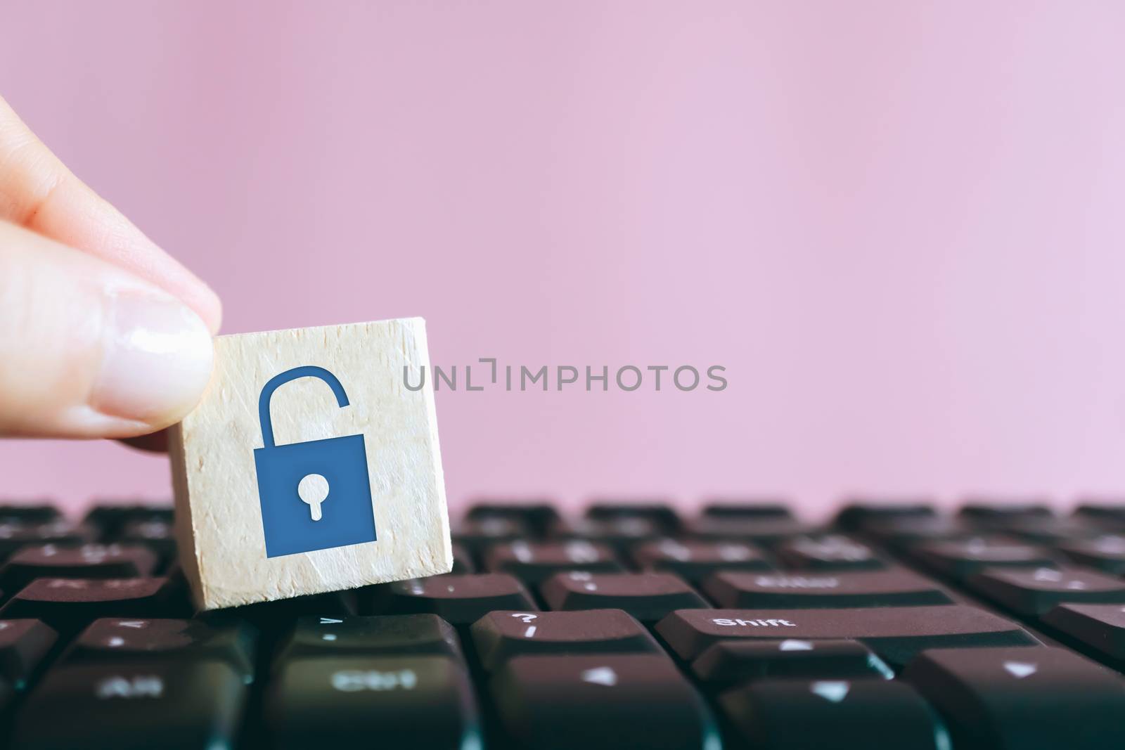 Closed up unlock icon as non security show on wood cube on computer keyboard. Protect safety on network activity business technology concept.