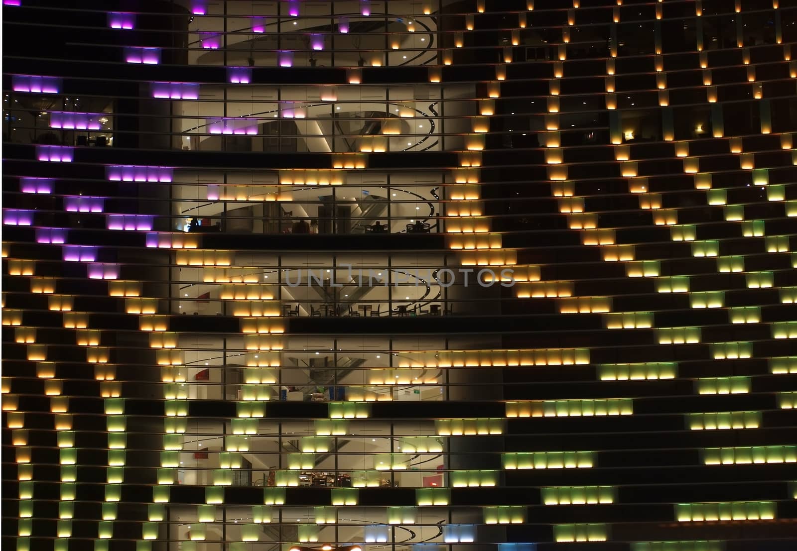 A lit up modern facade of a commercial building
