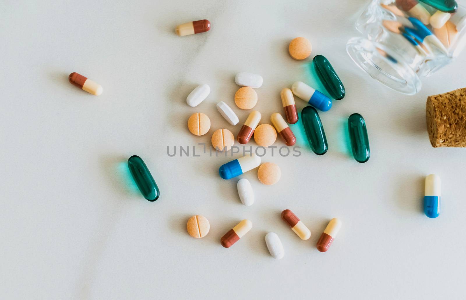 Top view of medicine tablets pour from pills bottle of marble texture white background. Health care medical lifestyle. by Suwant