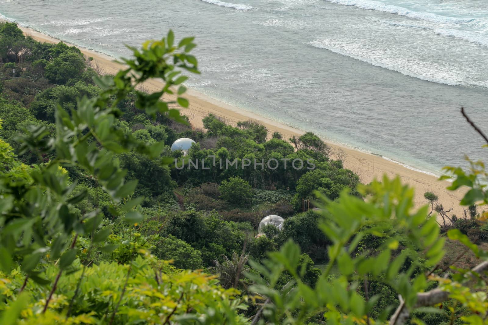 Bubble hotel at Nyang Nyang Beach on Bali Island, Indonesia. Romantic place ideal for honeymoon. A high reef off the coast of the Indian Ocean overgrown with dense tropical vegetation. Rainforest.