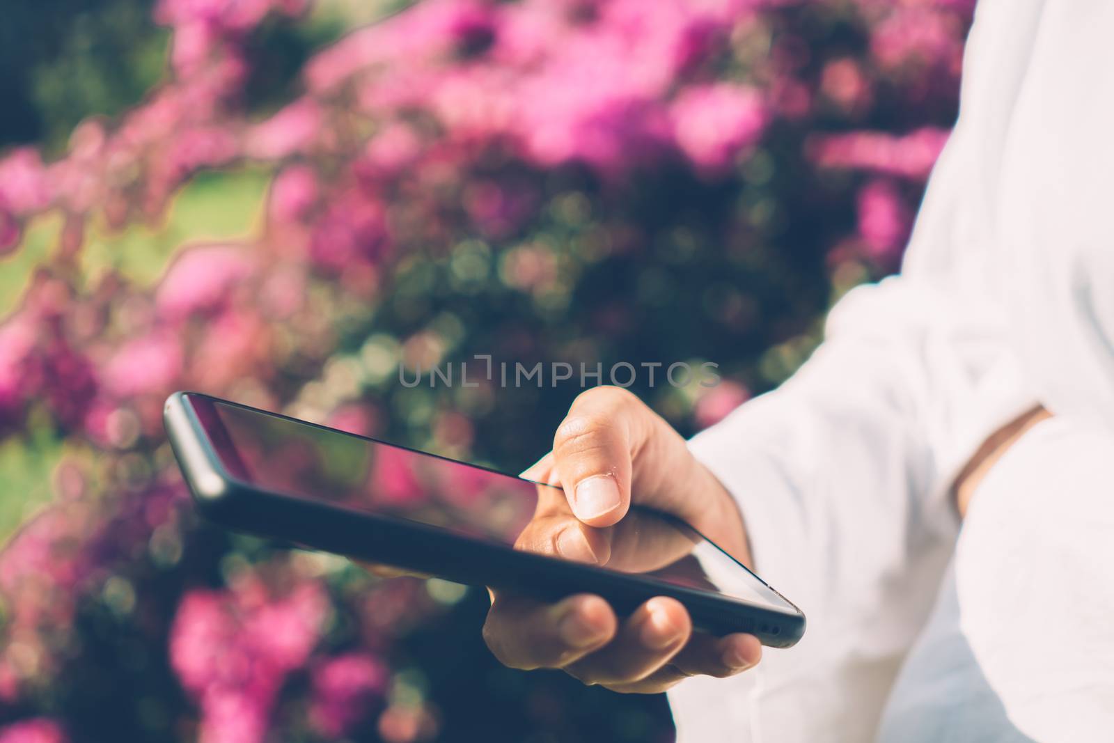 Woman hand use smartphone to do work business, social network, communication in public nature space.