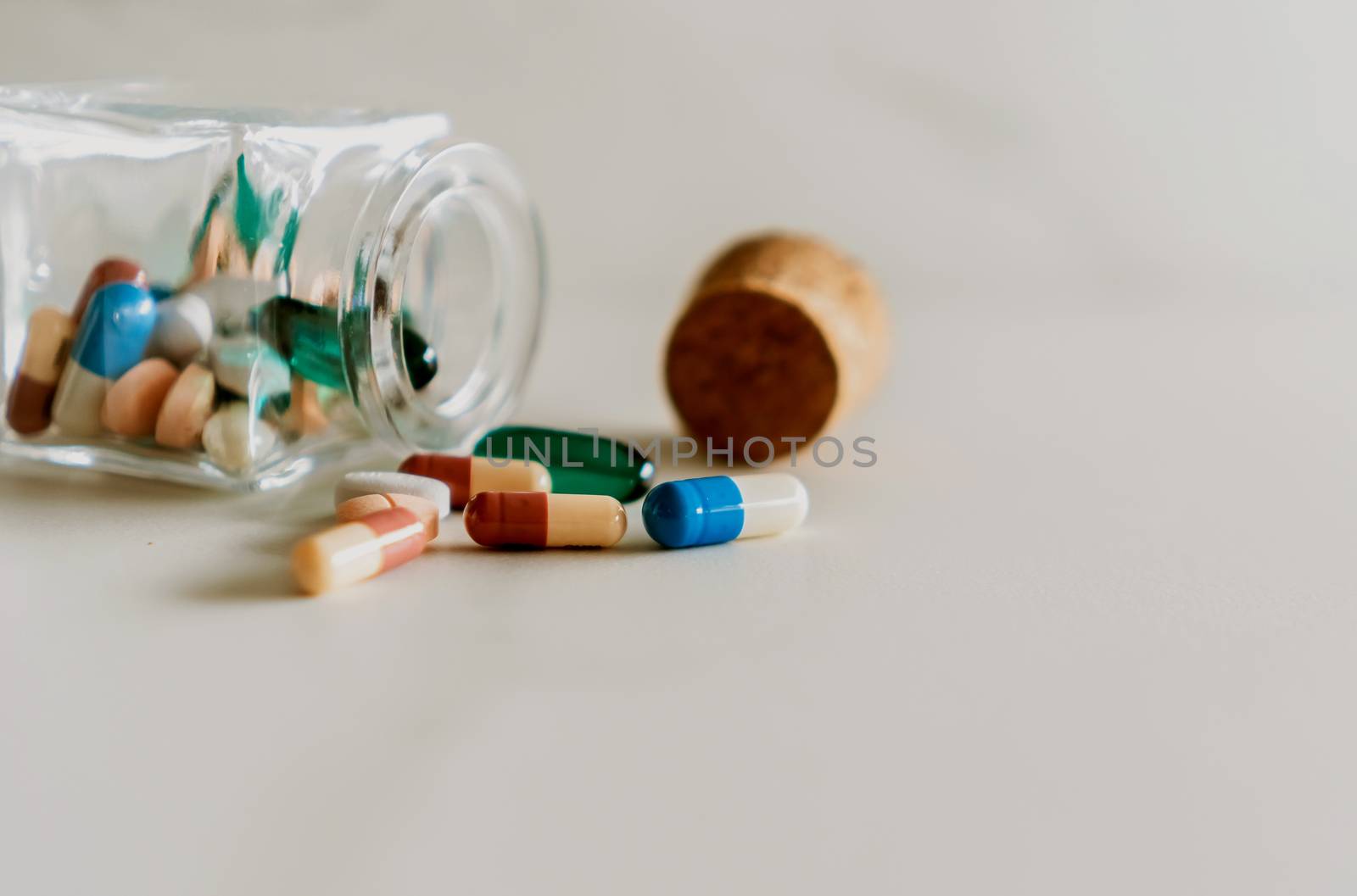 Top view of medicine tablets pour from pills bottle of marble texture white background. Health care medical lifestyle trend concept.