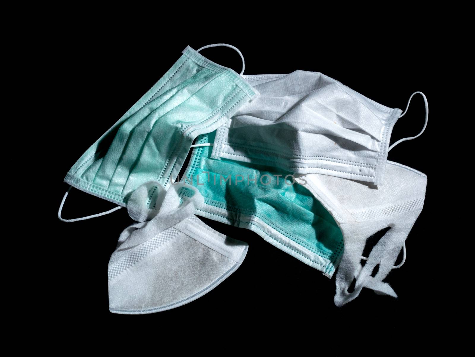 used surgical masks and used PM2.5 masks place on black background  dark tone. Properly discarded mask concept.