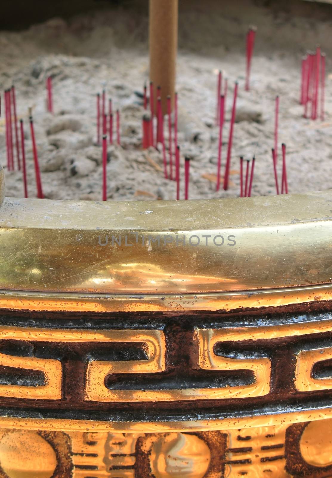 -- with red incense sticks placed amidst the ashes
