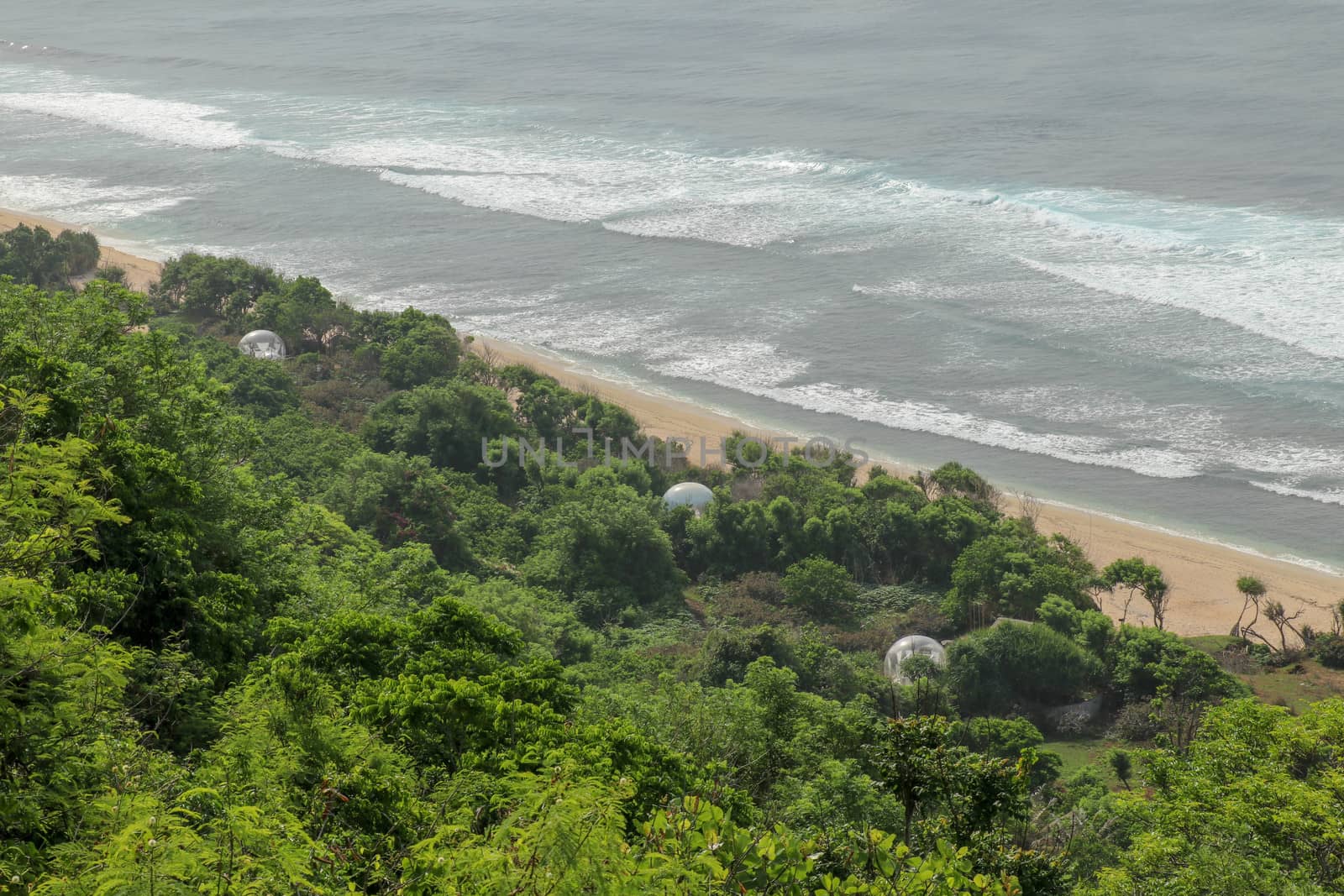 Bubble hotel at Nyang Nyang Beach on Bali Island, Indonesia. Romantic place ideal for honeymoon. A high reef off the coast of the Indian Ocean overgrown with dense tropical vegetation. Rainforest.