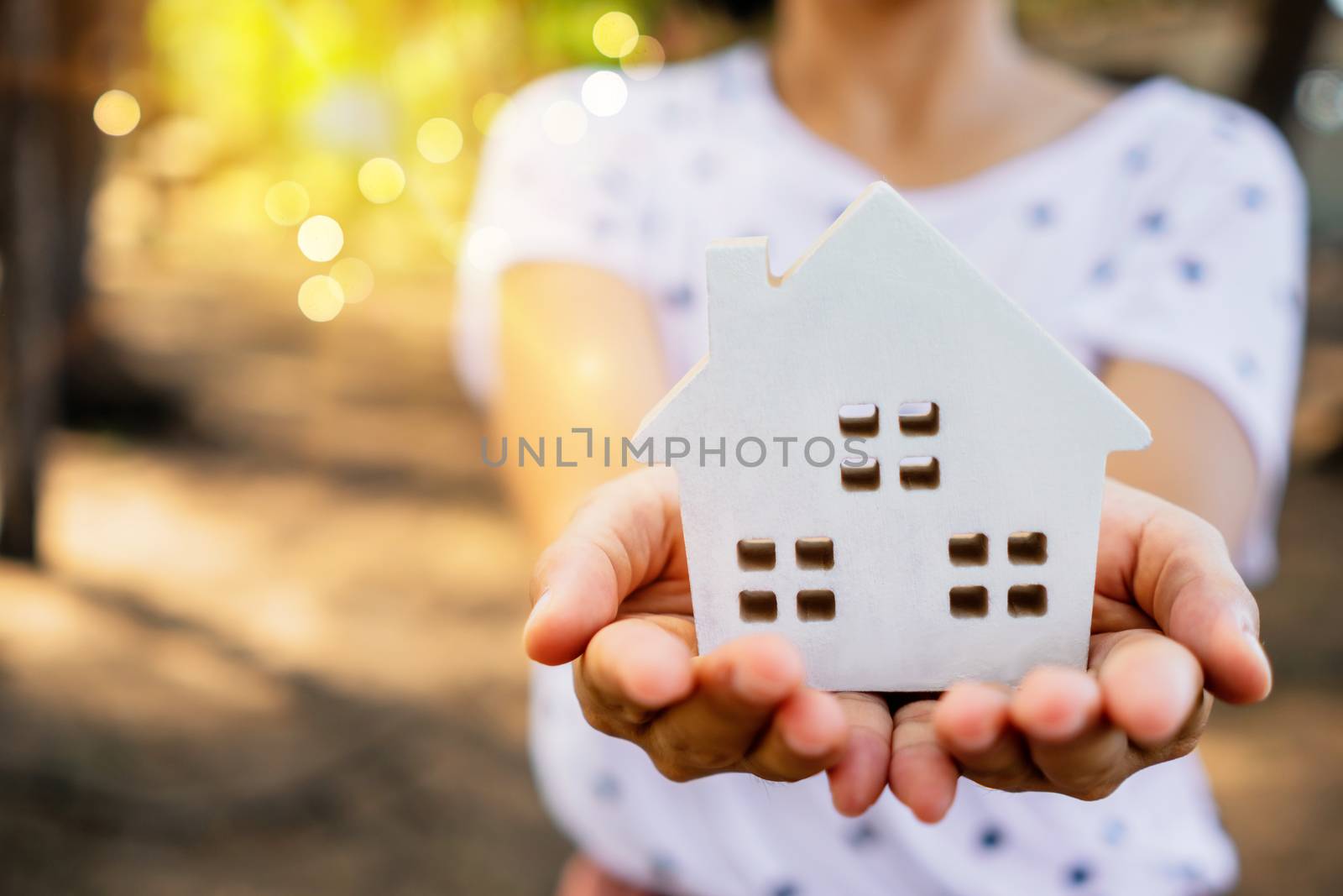 Copyspace model of a little house that woman holds it background. by Suwant