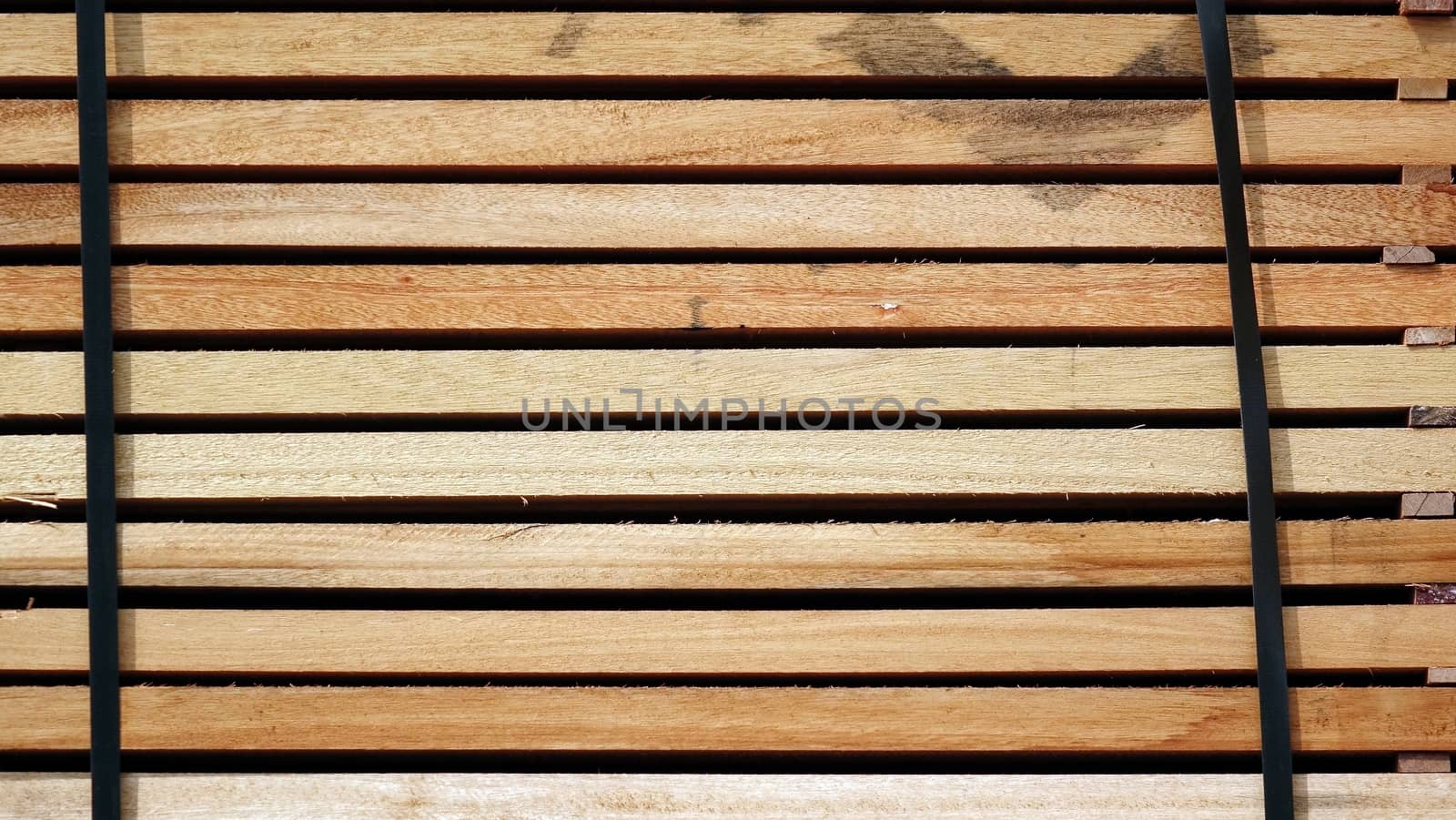 Wooden timber boards are stacked at a lumber yard