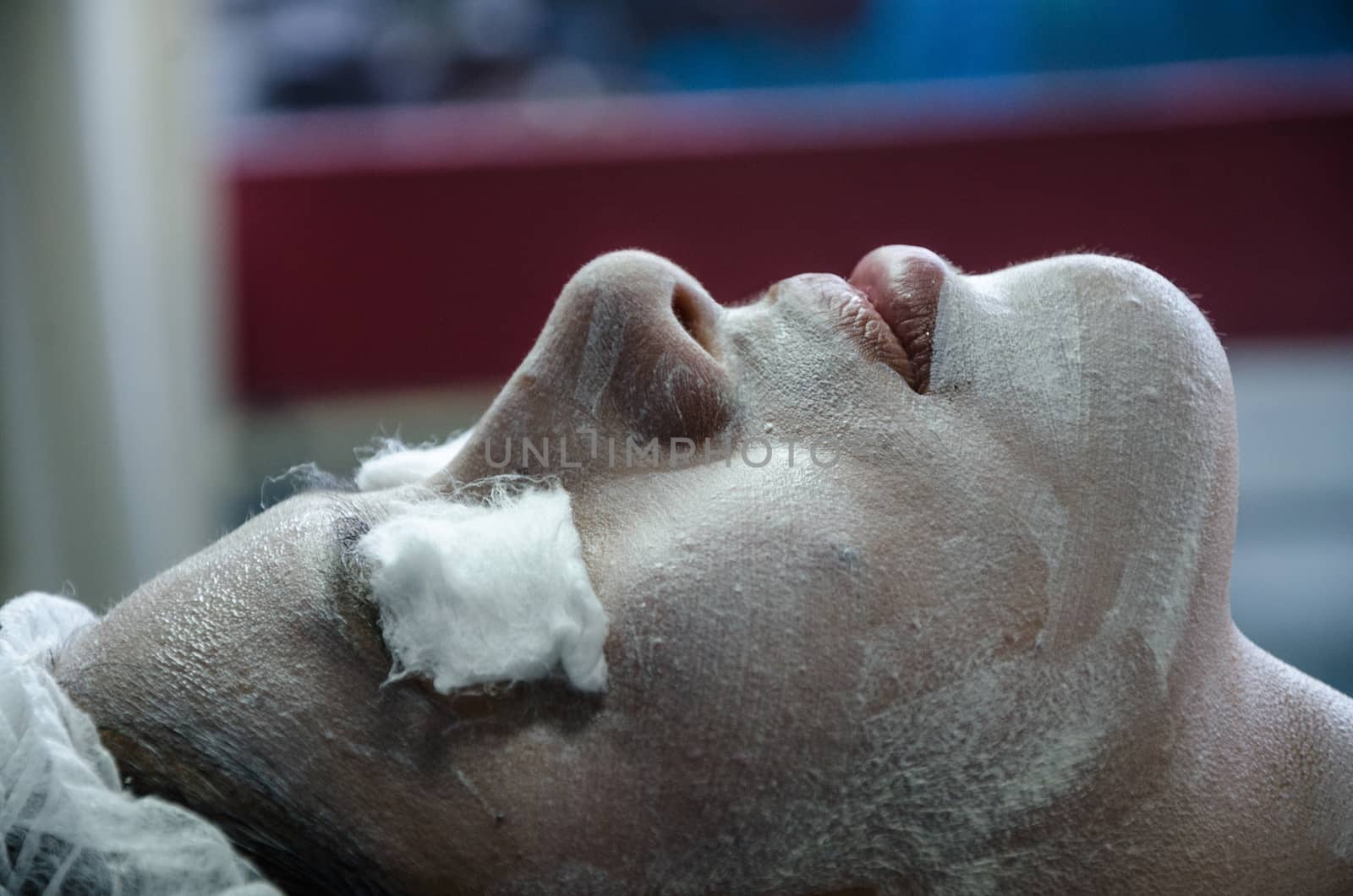 Cosmiatra performing facial cleansing on a patient