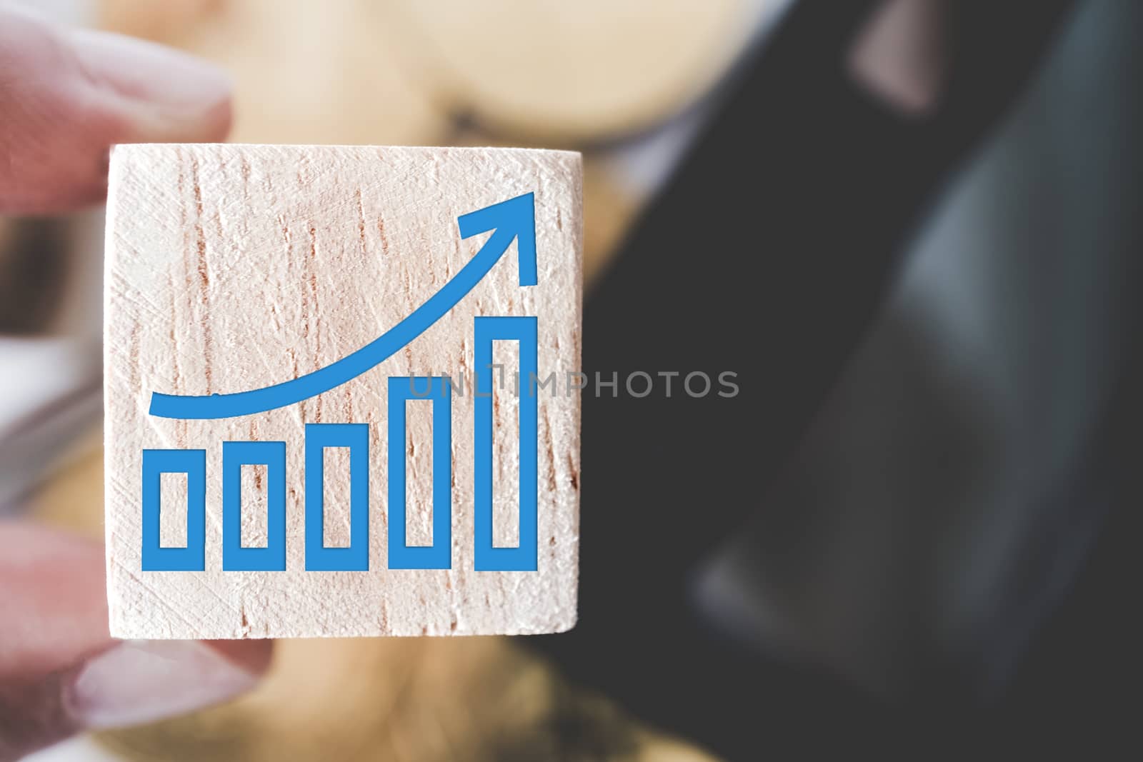 Graph rising up growht exponencial sign on wooden cube with objects such as gold coin, calculator and mini home model behide white clean background. Business financial loan property concept.