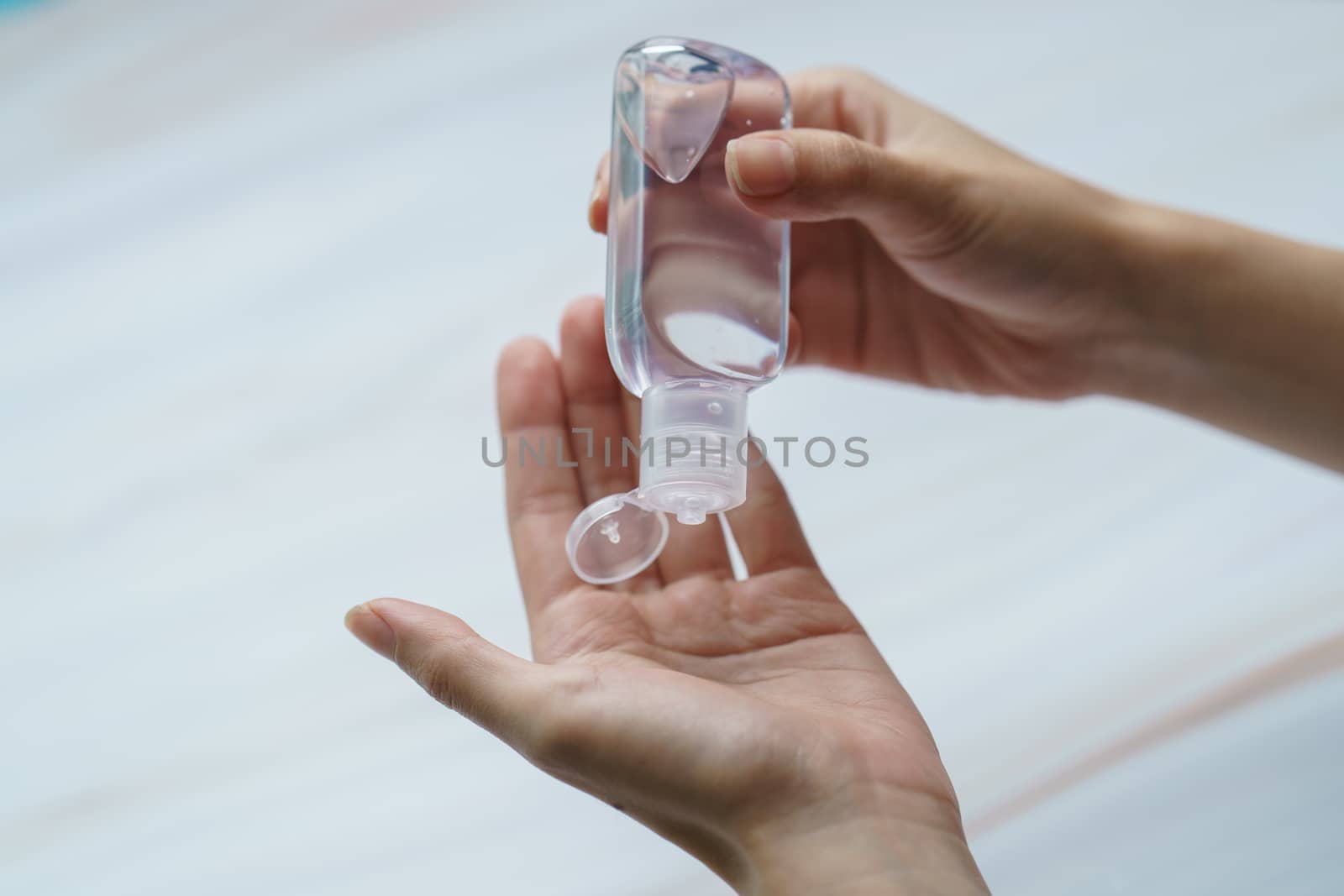 Close up woman using antibacterial hand sanitizer on hands. by sirawit99