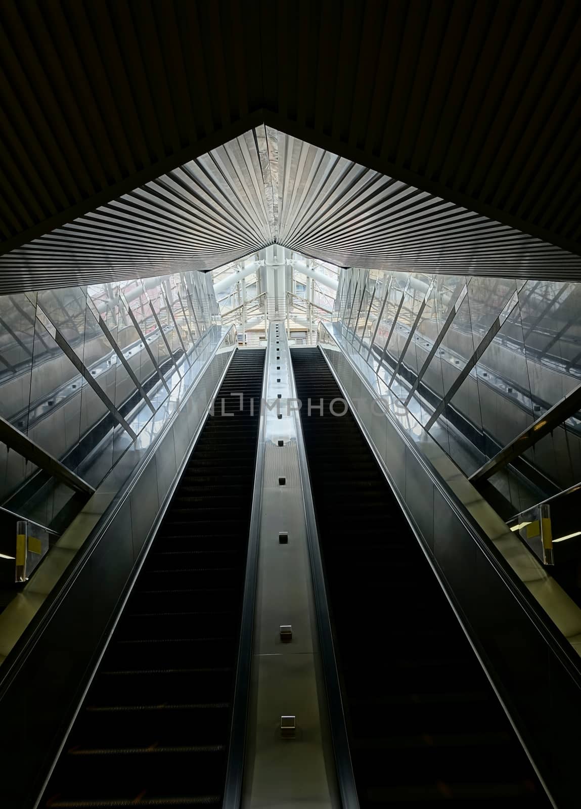 A set of long escalators lead out of a pedestrian underground passage
